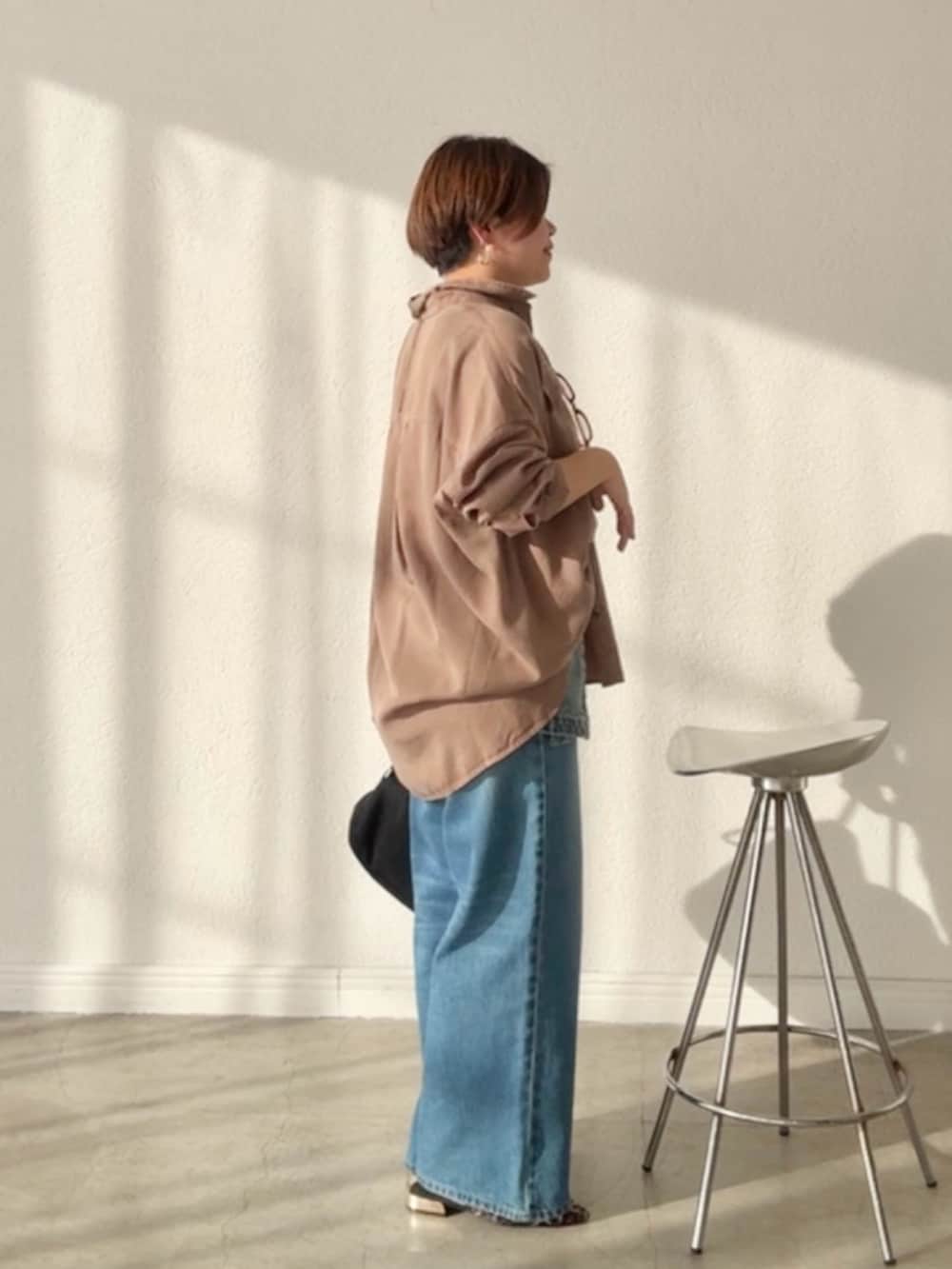 ブラウン系のシャツ/ブラウス、ブルー系のデニムスカート、ブルー系のデニムパンツを着用したレディースの春コーディネートの2枚目の写真