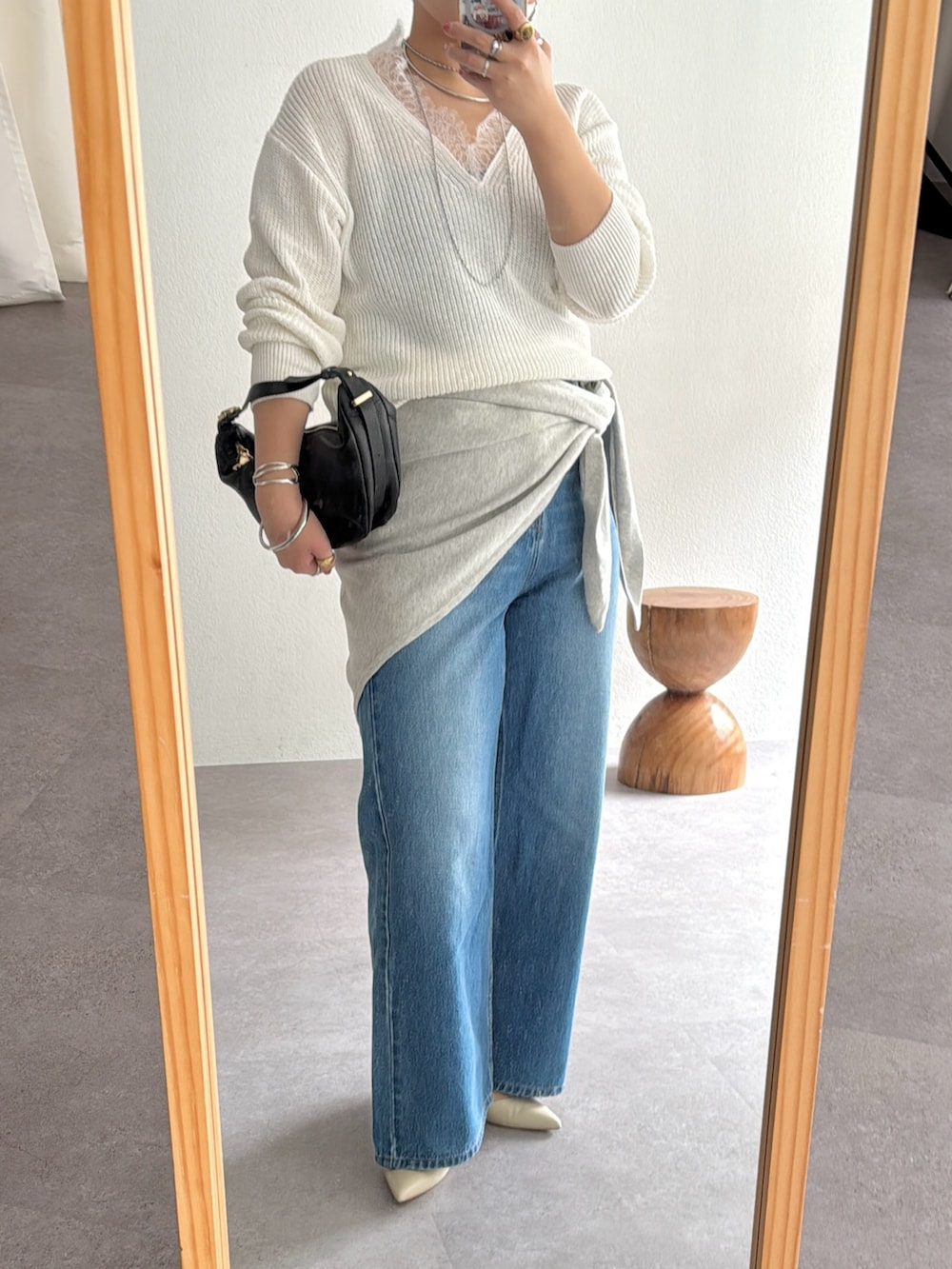 ホワイト系のニット/セーター、ブルー系のデニムパンツ、グレー系のストール/ショールを着用したレディースの冬コーディネートの3枚目の写真