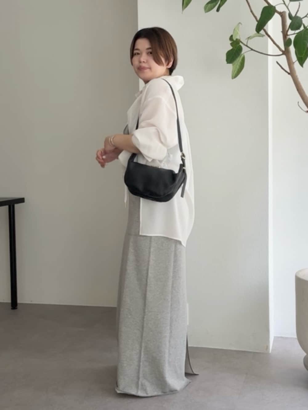 ホワイト系のシャツ/ブラウス、グレー系のスカート、ブラック系のショルダーバッグを着用したレディースの春コーディネートの2枚目の写真