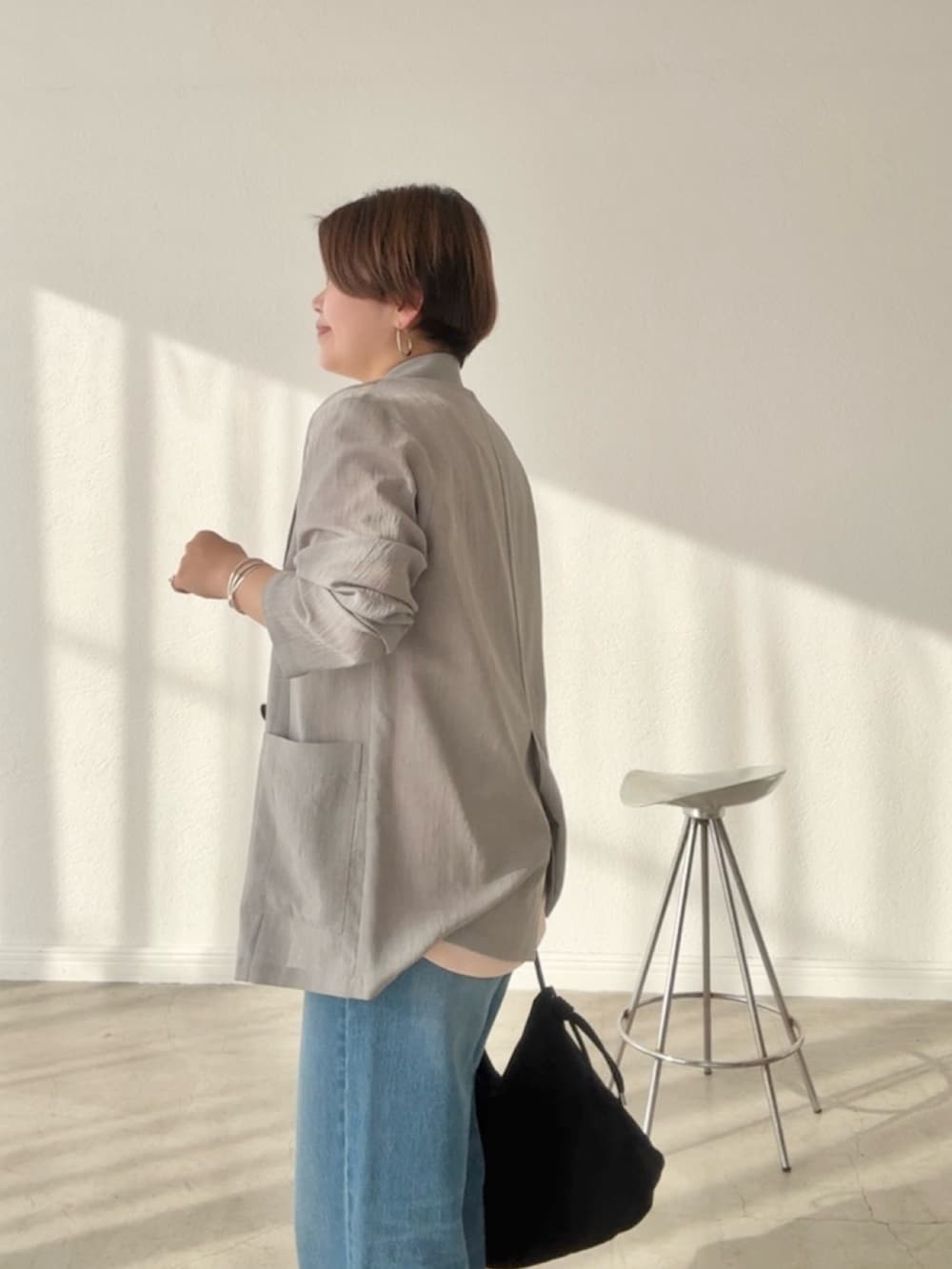 ブルー系のデニムパンツ、ピンク系のTシャツ/カットソー、グレー系のテーラードジャケットを着用したレディースの春コーディネートの4枚目の写真