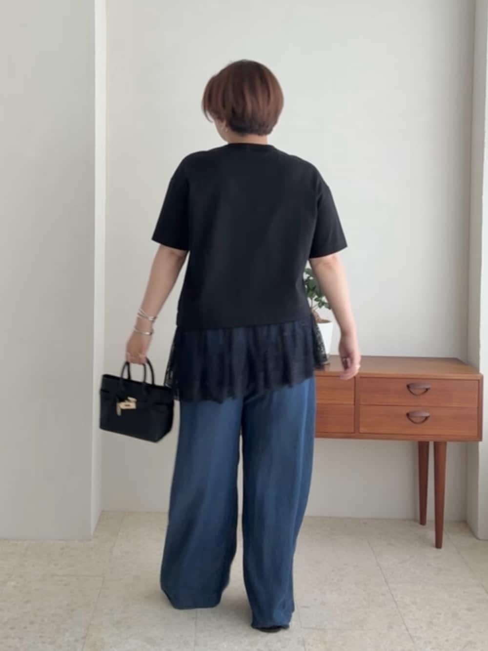 ブラック系のTシャツ/カットソー、ブルー系のデニムパンツを着用したレディースの夏コーディネートの3枚目の写真