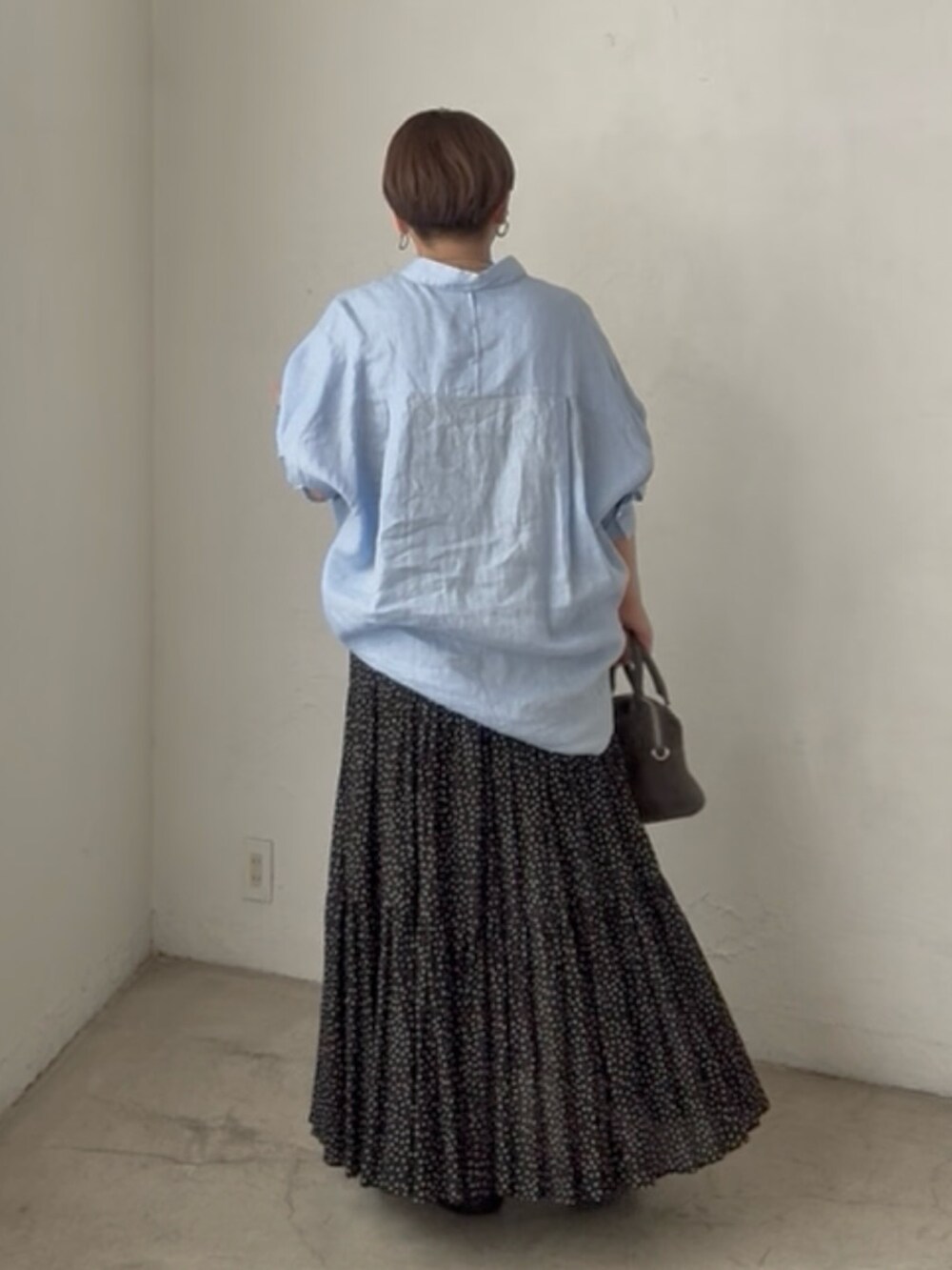 ブルー系のシャツ/ブラウス、ブラック系のスカートを着用したレディースの夏コーディネートの2枚目の写真