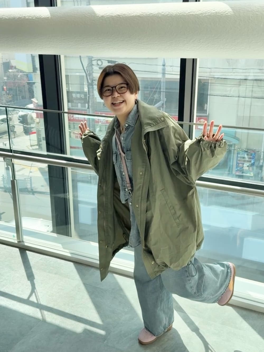 グリーン系のその他アウター、ブルー系のシャツ/ブラウス、ブルー系のデニムパンツを着用したレディースの春コーディネートの4枚目の写真