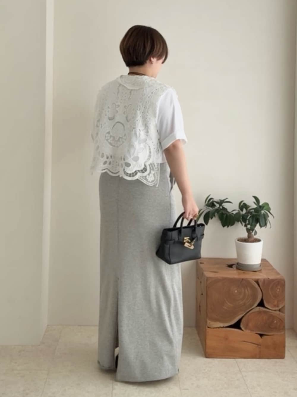 ホワイト系のTシャツ/カットソー、ホワイト系のベスト、グレー系のスカートを着用したレディースの夏コーディネートの2枚目の写真