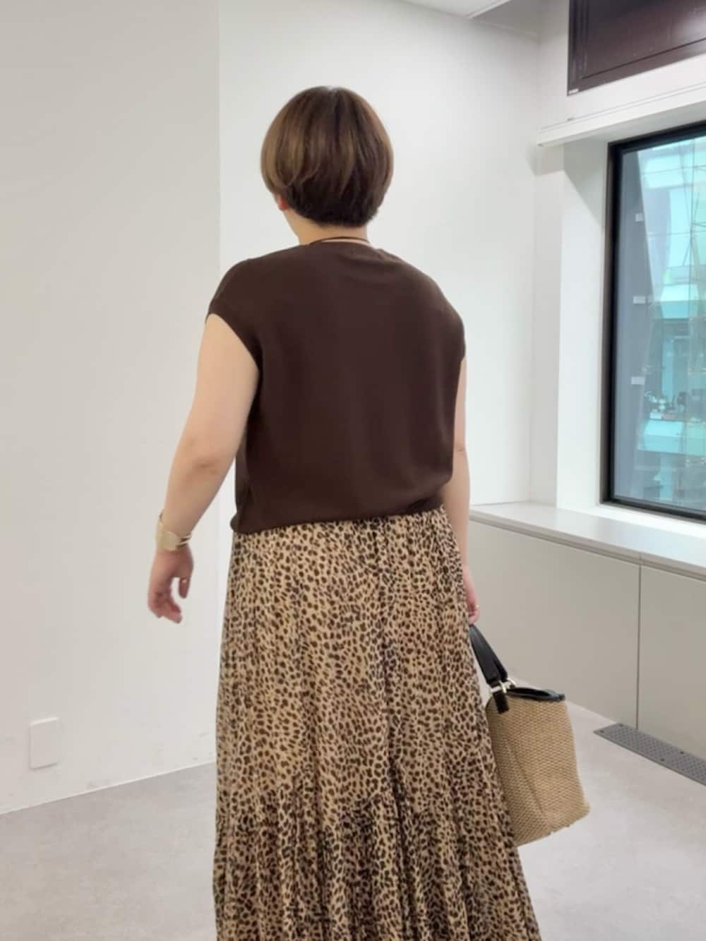ブラウン系のニット/セーター、ベージュ系のスカートを着用したレディースの夏コーディネートの4枚目の写真