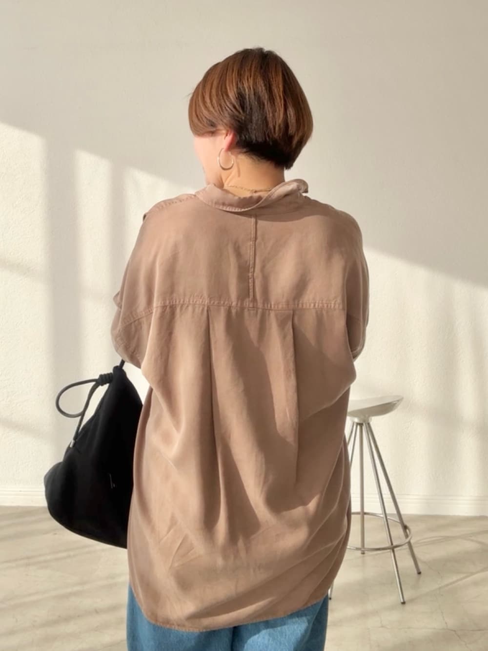 ブラウン系のシャツ/ブラウス、ブルー系のデニムスカート、ブルー系のデニムパンツを着用したレディースの春コーディネートの6枚目の写真