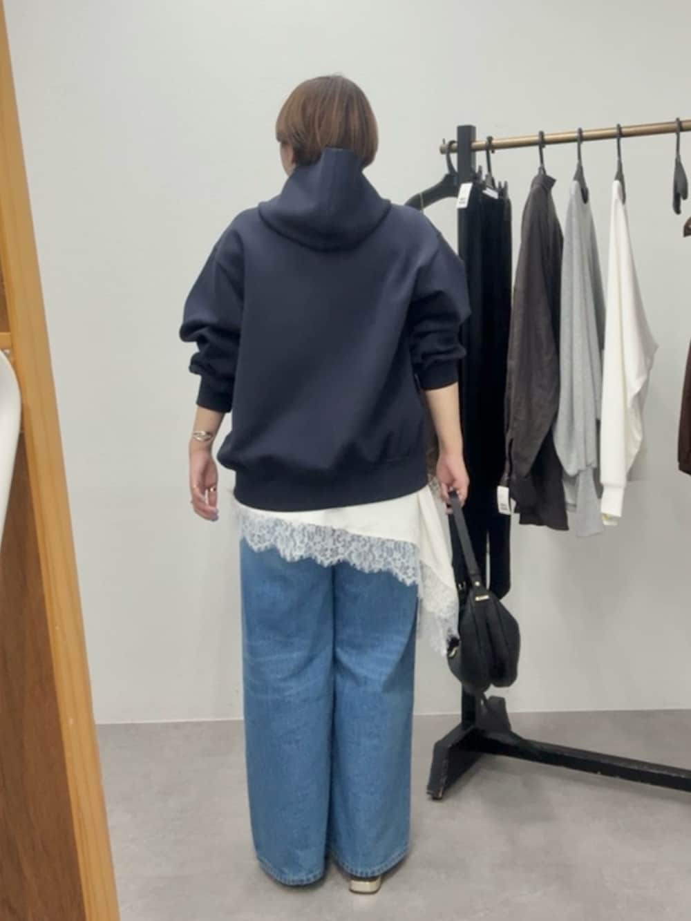 ブルー系のパーカー、ホワイト系のキャミソール、ブルー系のデニムパンツを着用したレディースの春コーディネートの4枚目の写真