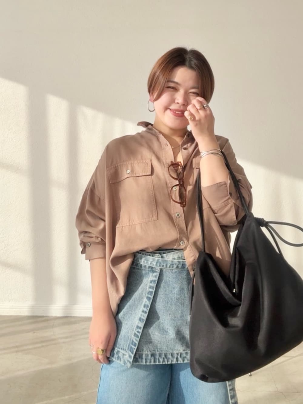 ブラウン系のシャツ/ブラウス、ブルー系のデニムスカート、ブルー系のデニムパンツを着用したレディースの春コーディネートの4枚目の写真