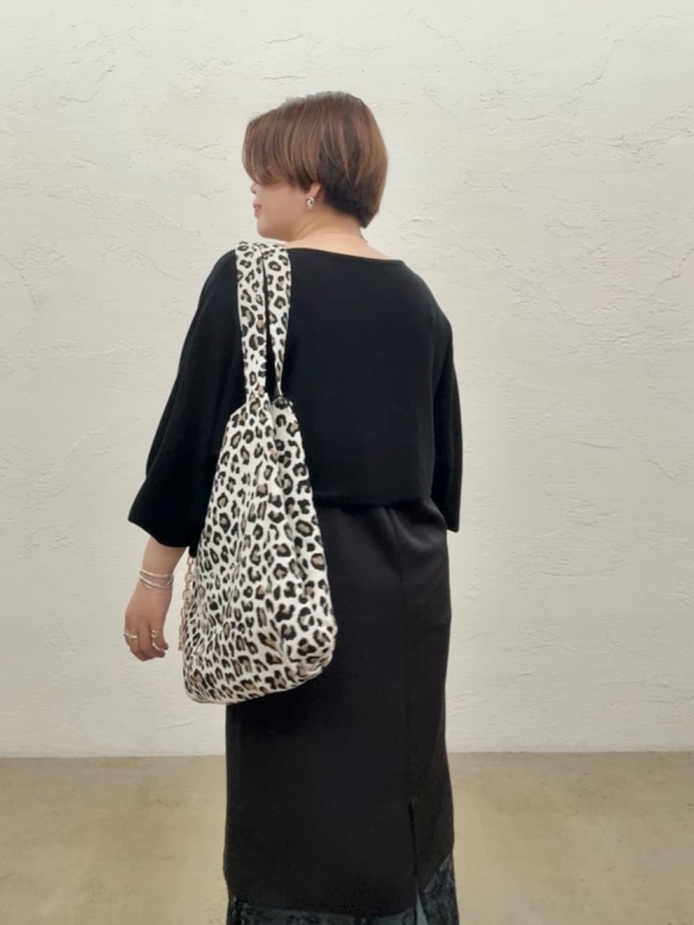ブラック系のニット/セーター、ブラック系のワンピース、ブルー系のデニムパンツを着用したレディースの夏コーディネートの7枚目の写真