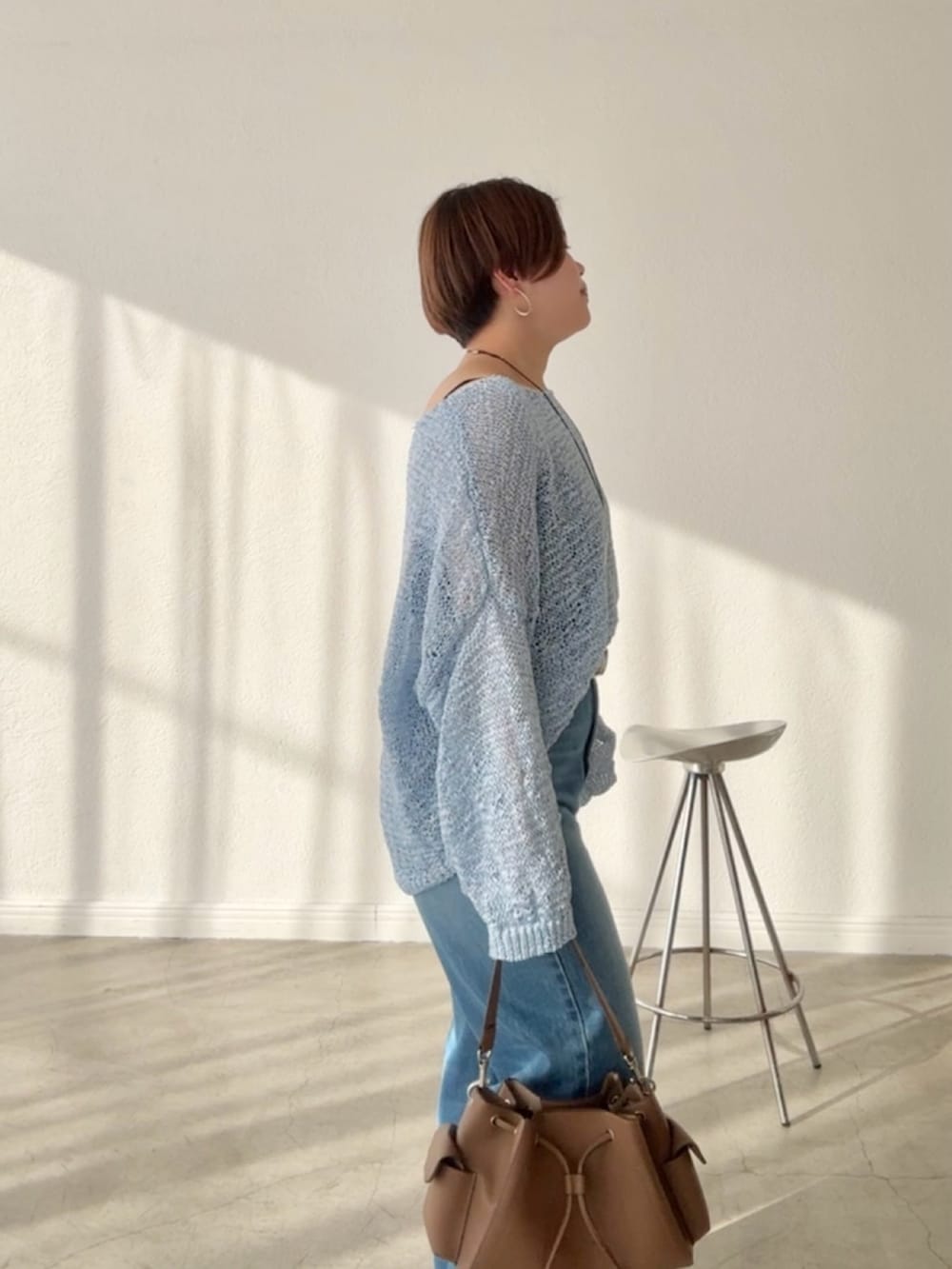 ブルー系のデニムパンツ、ブルー系のニット/セーターを着用したレディースの春コーディネートの5枚目の写真