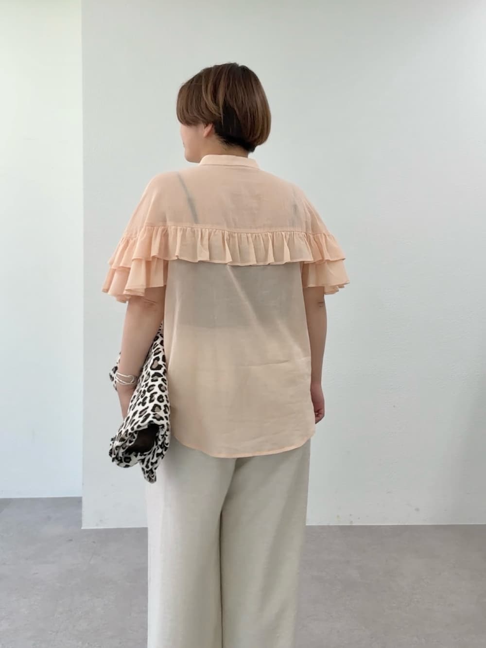 ピンク系のシャツ/ブラウス、ベージュ系のその他パンツ、ベージュ系のトートバッグを着用したレディースの春コーディネートの6枚目の写真