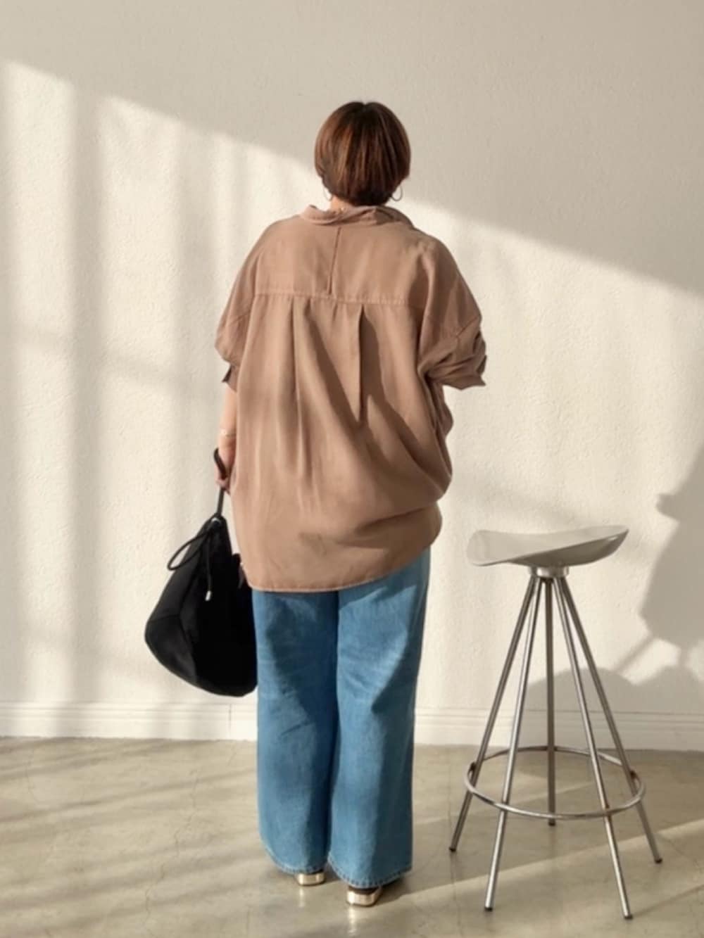 ブラウン系のシャツ/ブラウス、ブルー系のデニムスカート、ブルー系のデニムパンツを着用したレディースの春コーディネートの3枚目の写真