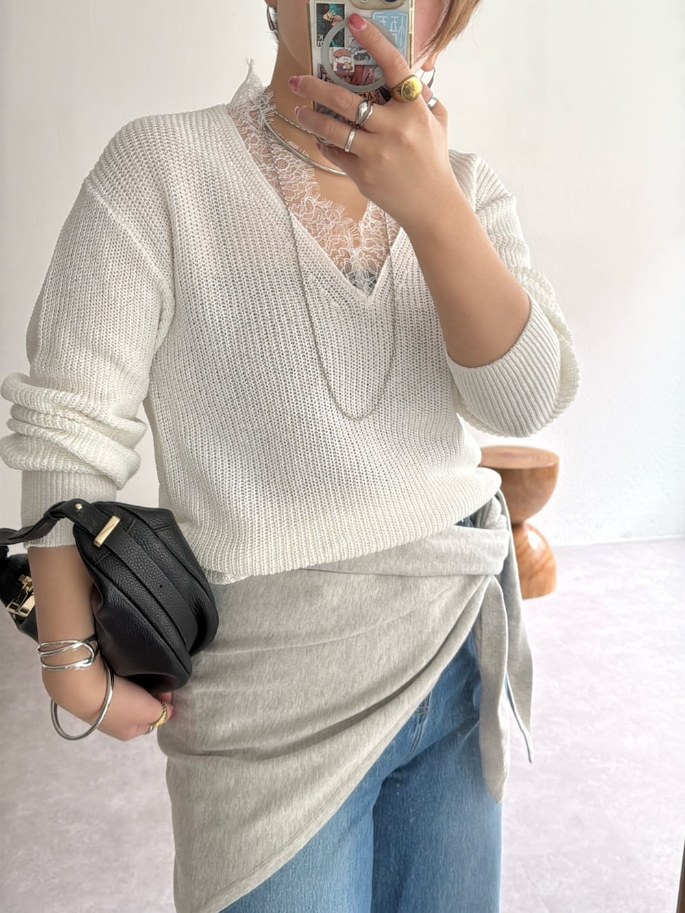 ホワイト系のニット/セーター、ブルー系のデニムパンツ、グレー系のストール/ショールを着用したレディースの冬コーディネートの2枚目の写真