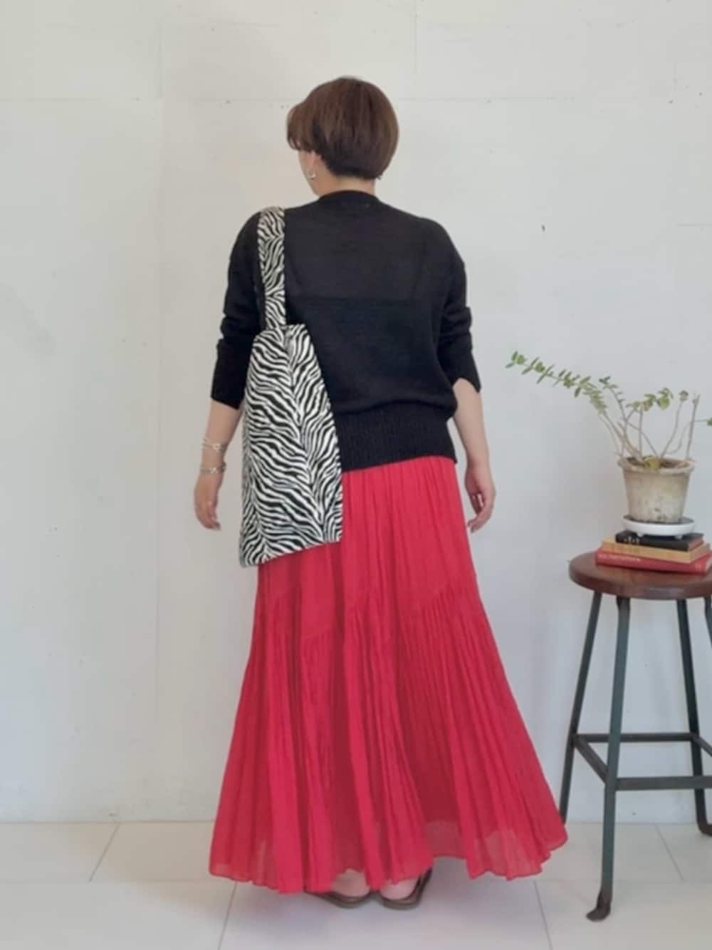 ブラック系のカーディガン/ボレロ、レッド系のスカート、ブラック系のトートバッグを着用したレディースの春コーディネートの3枚目の写真