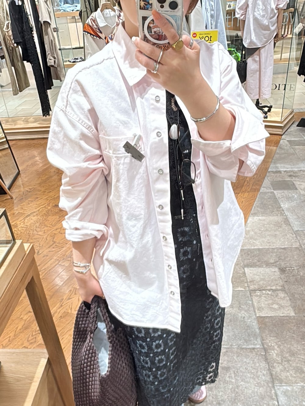 ブラック系のワンピース、ピンク系のシャツ/ブラウス、ブルー系のデニムパンツを着用したレディースの春コーディネートの2枚目の写真