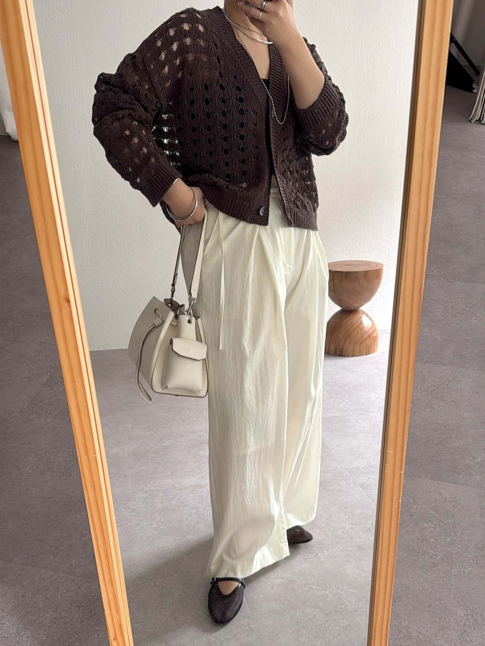 ブラウン系のカーディガン/ボレロ、ホワイト系のスラックス、ホワイト系のショルダーバッグを着用したレディースの冬コーディネートの3枚目の写真