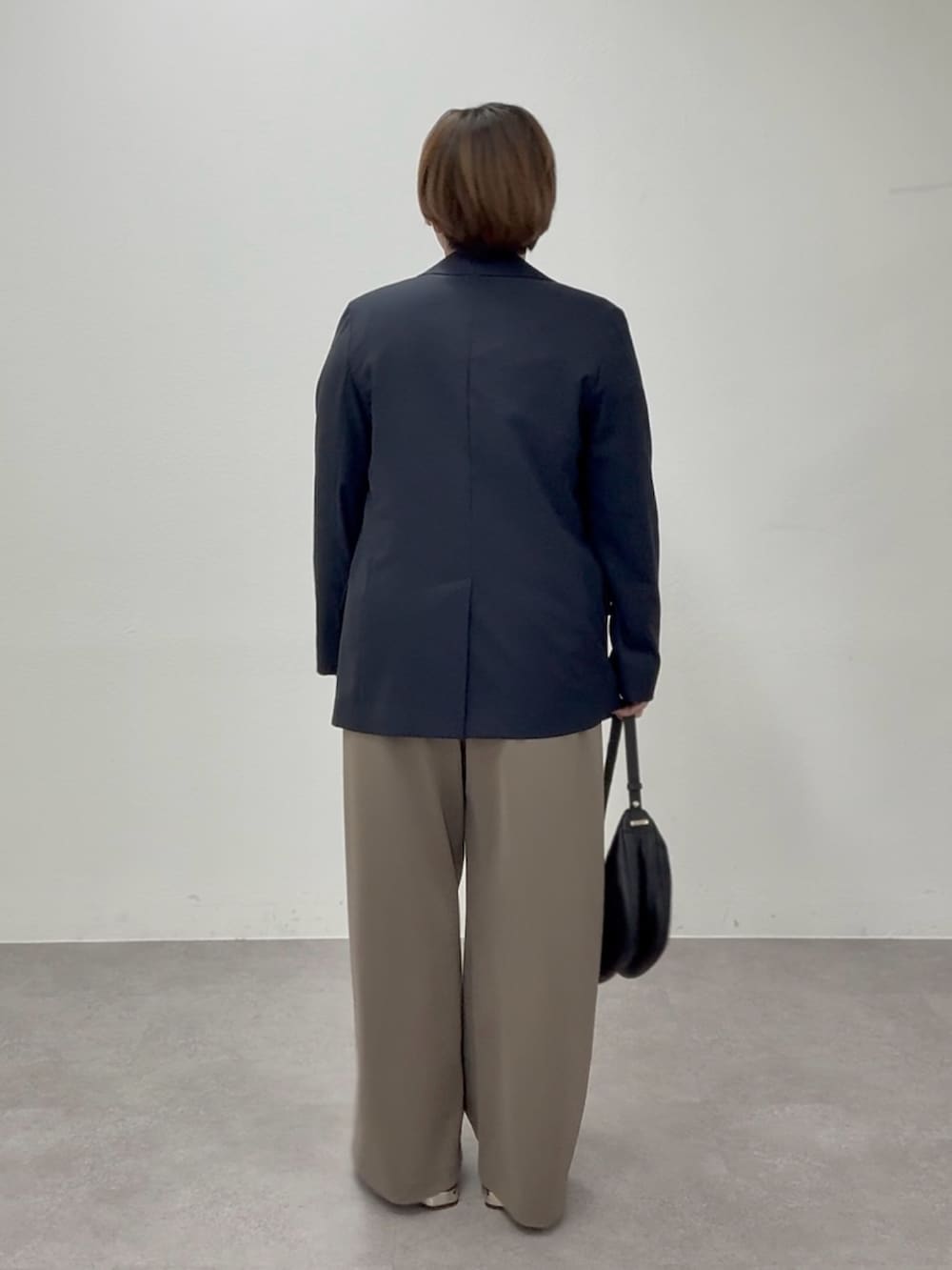 ブラック系のTシャツ/カットソー、ブラウン系のその他パンツ、ブルー系のテーラードジャケットを着用したレディースの春コーディネートの2枚目の写真