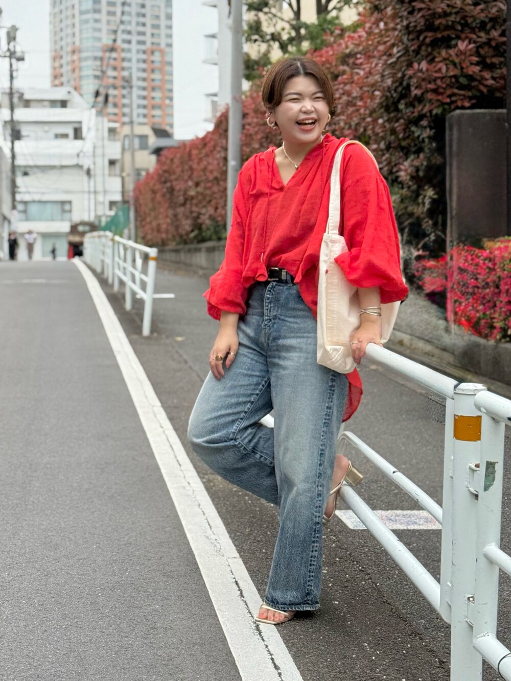 レッド系のシャツ/ブラウス、ブルー系のデニムパンツ、ホワイト系のハンドバッグを着用したレディースの春コーディネートの7枚目の写真