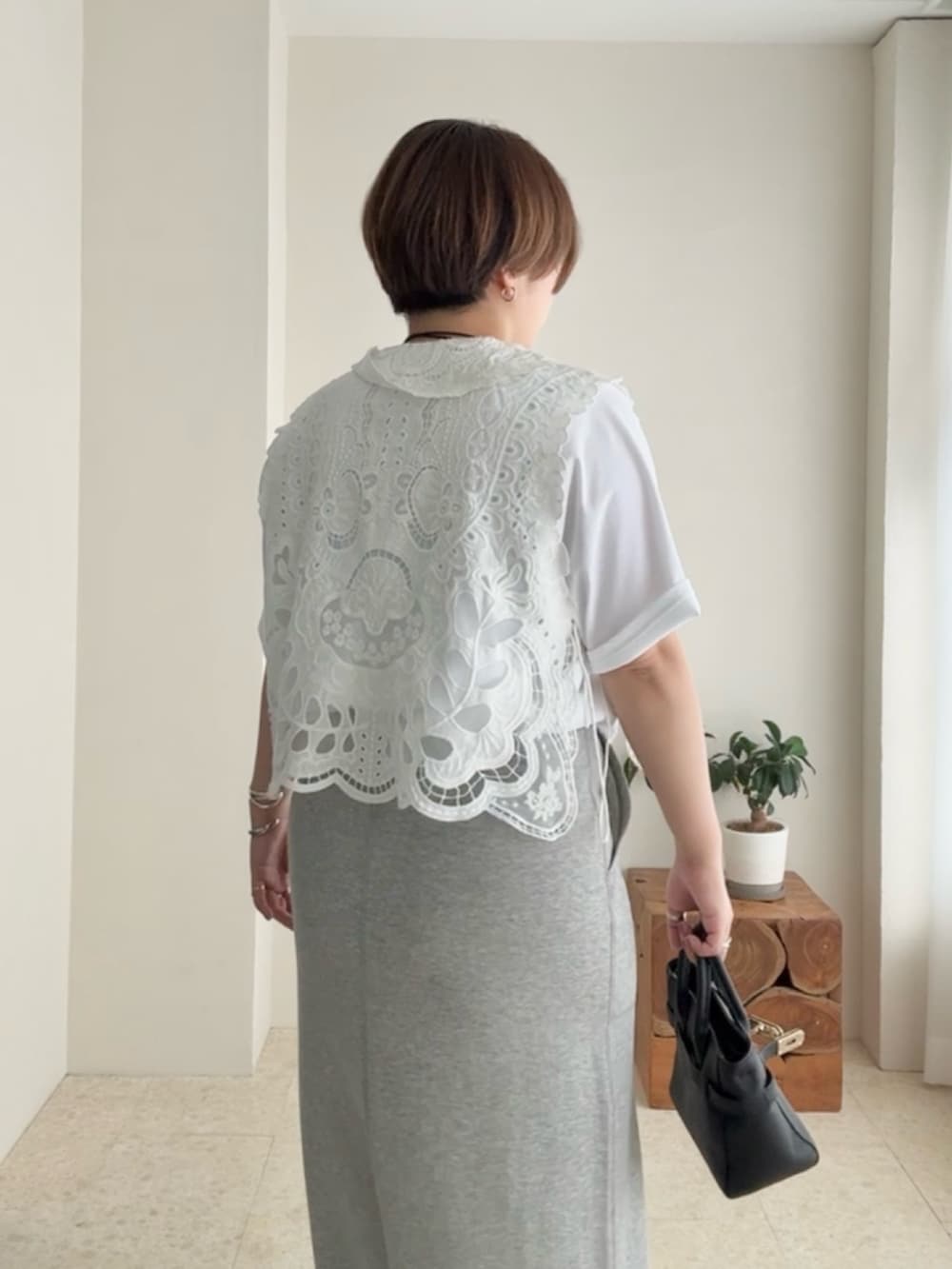 ホワイト系のTシャツ/カットソー、ホワイト系のベスト、グレー系のスカートを着用したレディースの夏コーディネートの5枚目の写真