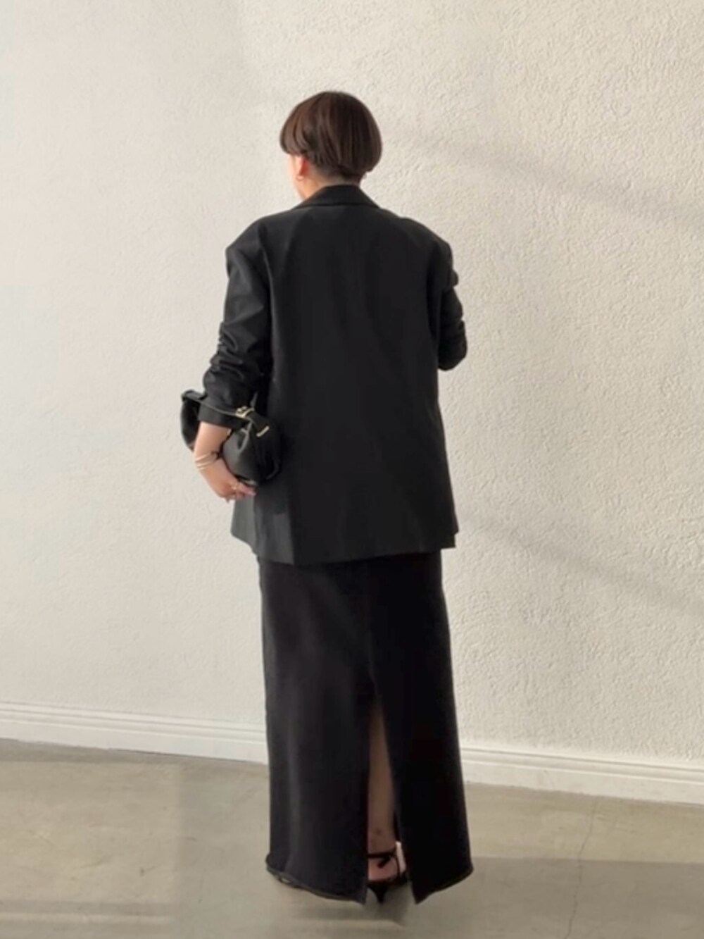 ブラック系のテーラードジャケット、ブラック系のスカート、ピンク系のTシャツ/カットソーを着用したレディースの春コーディネートの3枚目の写真