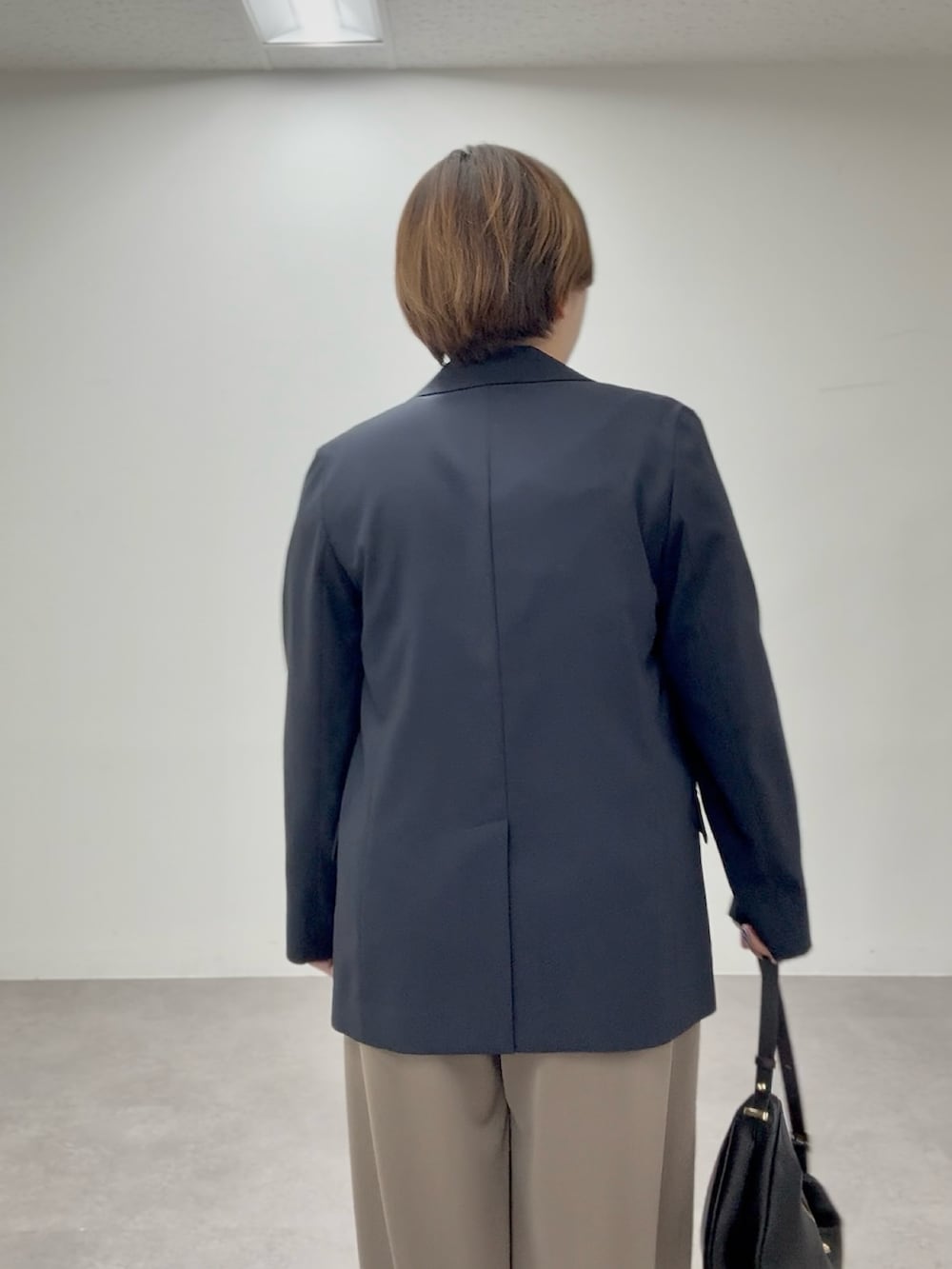 ブラック系のTシャツ/カットソー、ブラウン系のその他パンツ、ブルー系のテーラードジャケットを着用したレディースの春コーディネートの4枚目の写真