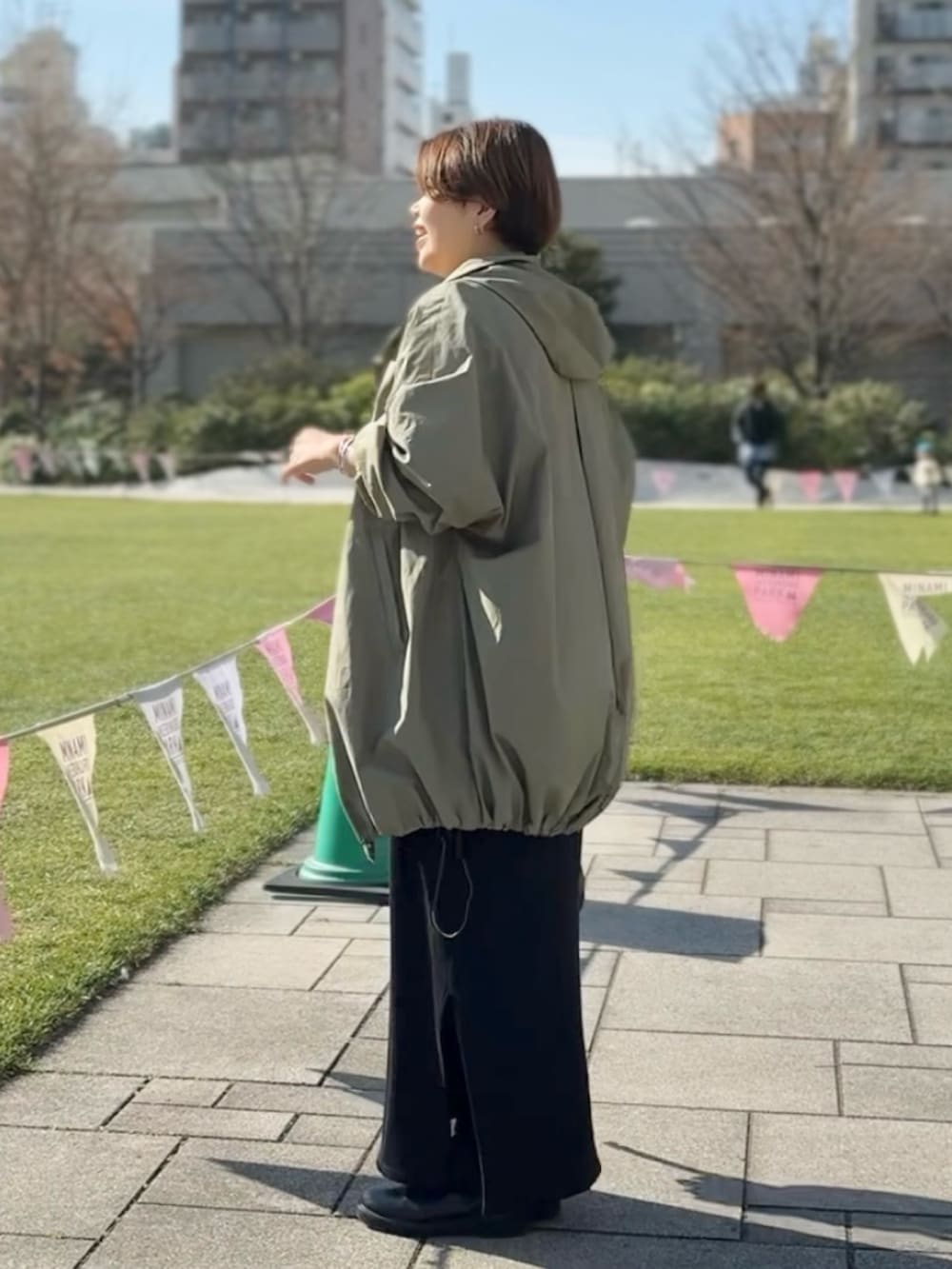 ブルー系のデニムスカート、ブラック系のワンピース、グリーン系のその他アウターを着用したレディースの冬コーディネートの2枚目の写真