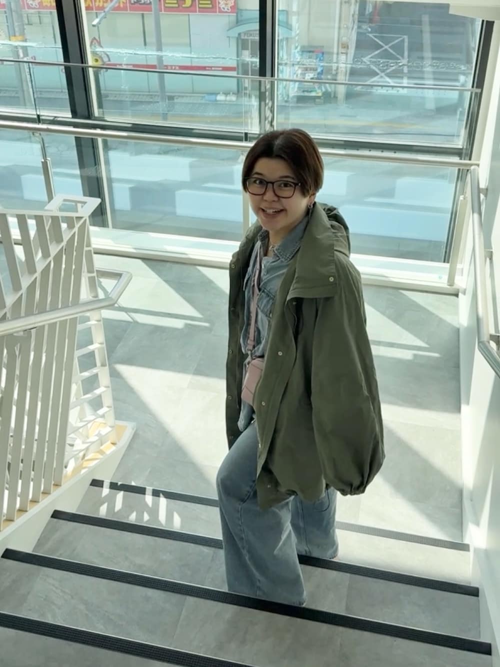 グリーン系のその他アウター、ブルー系のシャツ/ブラウス、ブルー系のデニムパンツを着用したレディースの春コーディネートの5枚目の写真