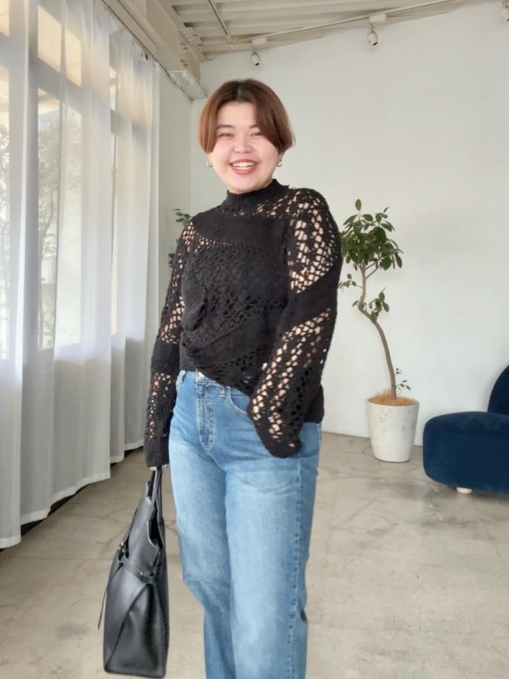 ブルー系のデニムパンツ、ブラック系のニット/セーターを着用したレディースの夏コーディネートの3枚目の写真