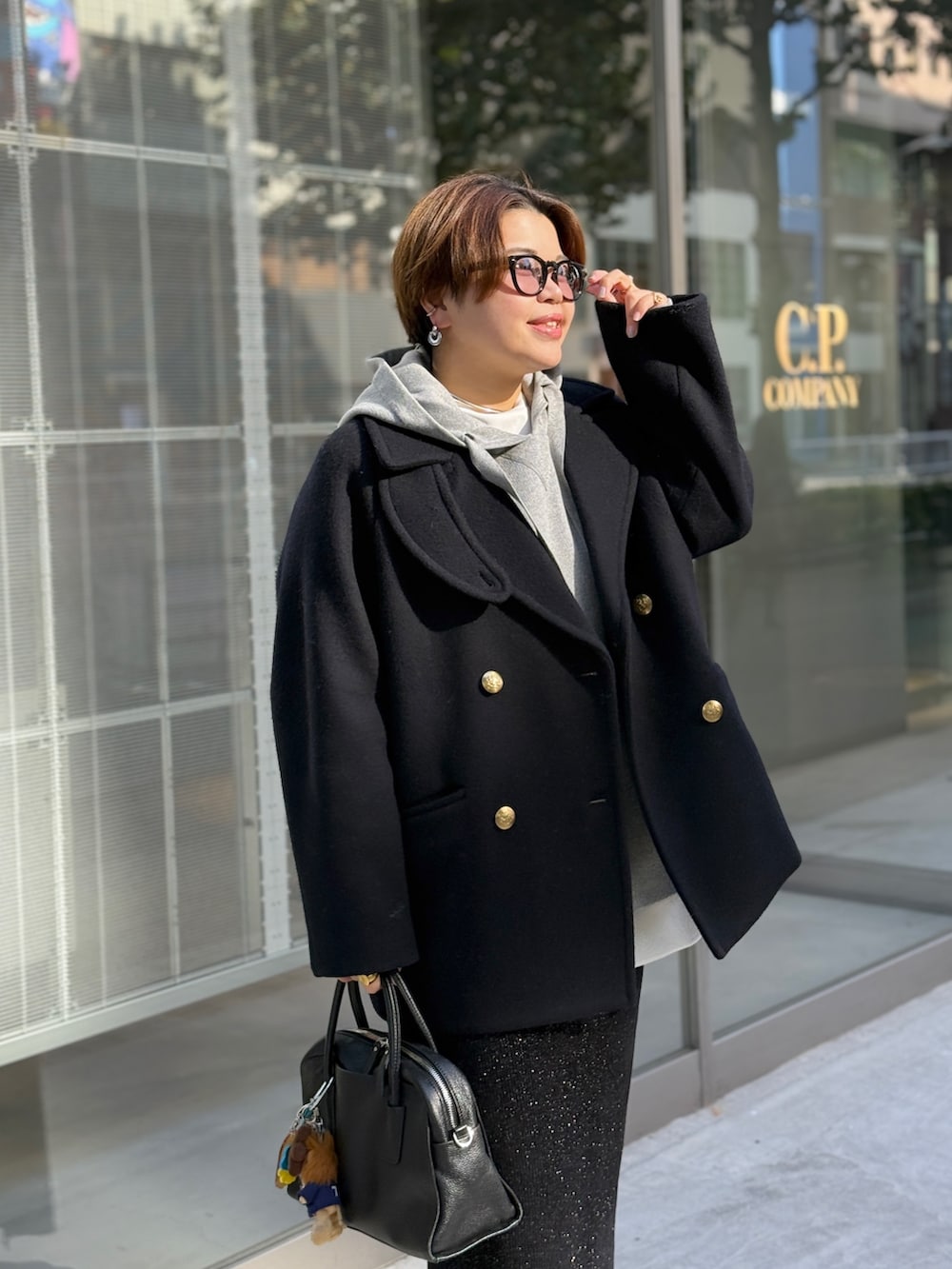 ブルー系のピーコート、ホワイト系のTシャツ/カットソー、ブラック系のスカートを着用したレディースの秋コーディネートの2枚目の写真