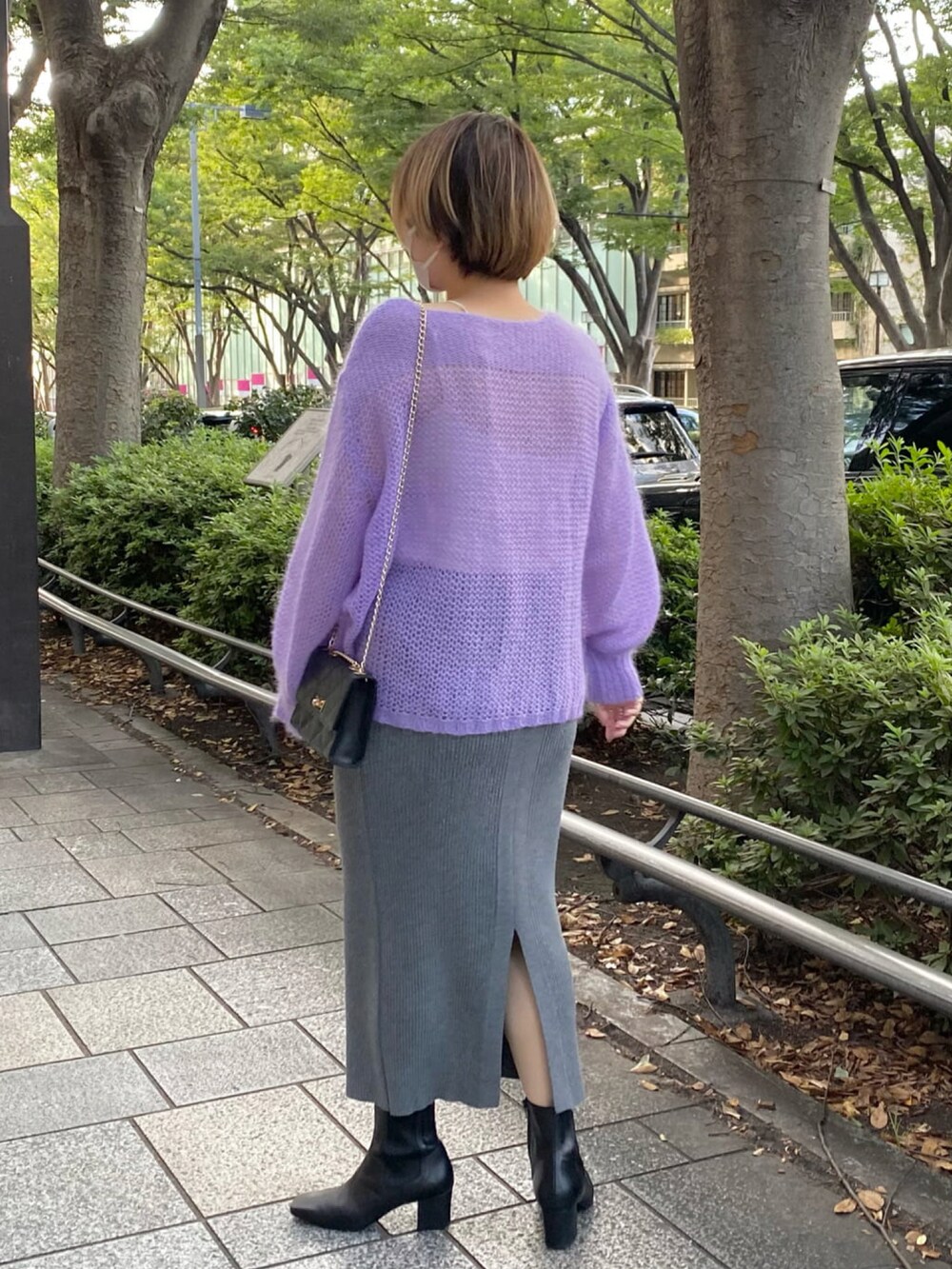 パープル系のニット/セーター、グレー系のスカート、ブラック系のブーツを着用したレディースの秋コーディネートの3枚目の写真