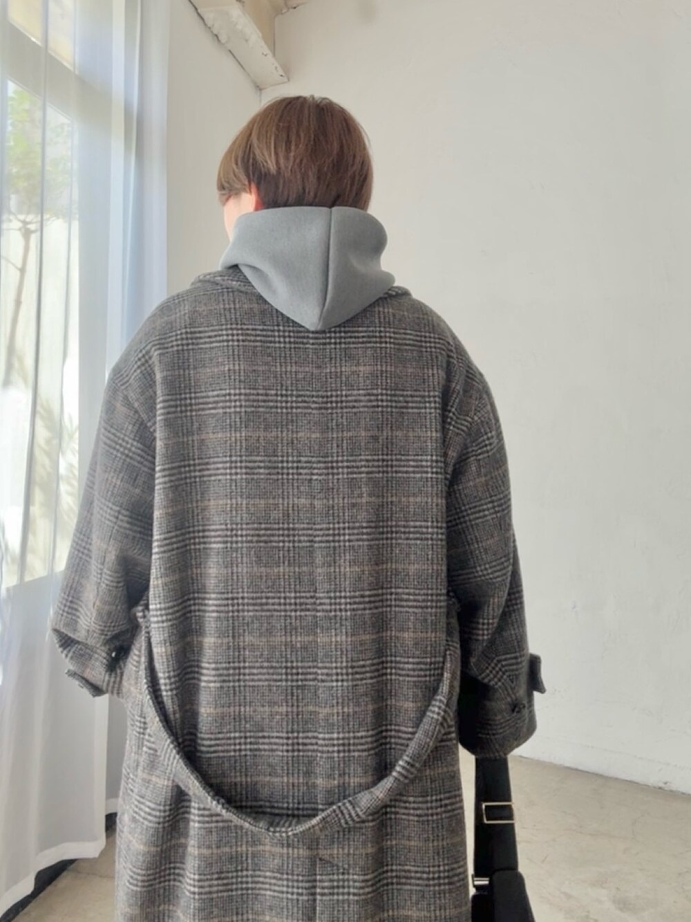 グレー系のパーカー、ブラウン系のスカートを着用したレディースの秋コーディネートの6枚目の写真