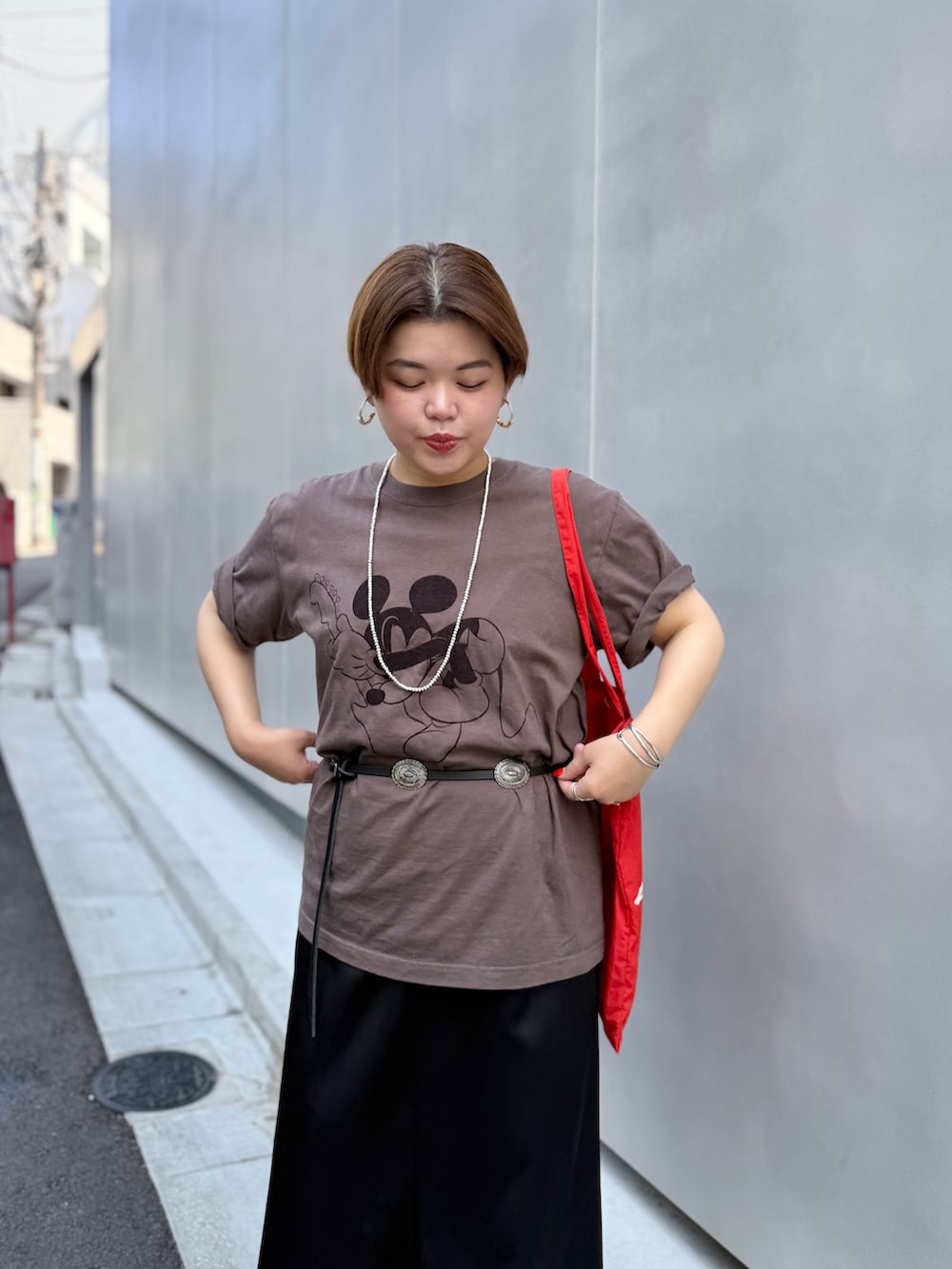 ブラウン系のTシャツ/カットソー、ブラック系のワンピース、レッド系のトートバッグを着用したレディースの夏コーディネートの2枚目の写真