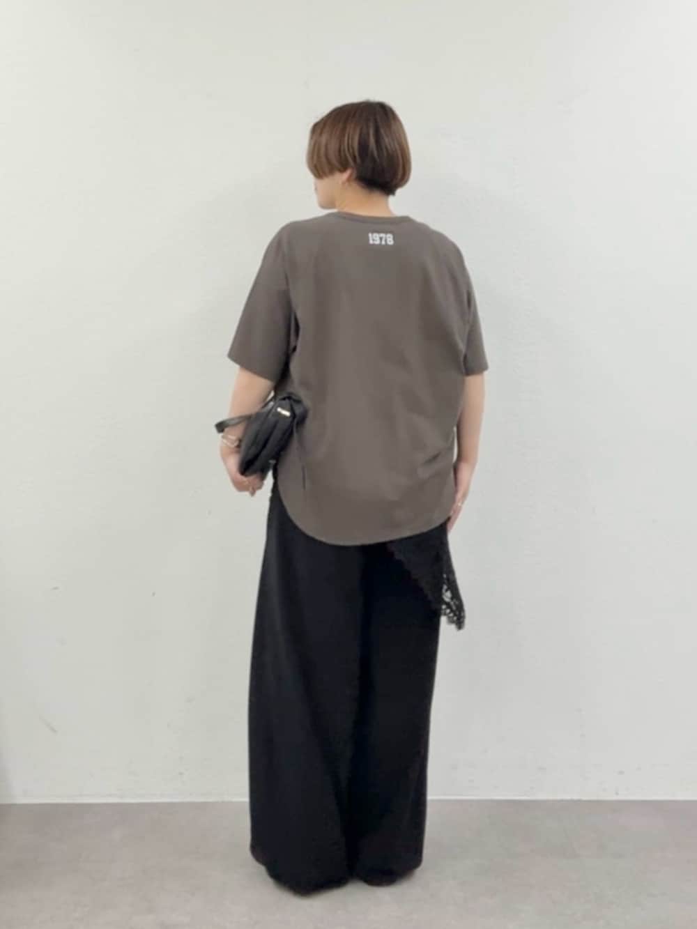 ブラウン系のTシャツ/カットソー、ブラック系のスラックス、ブラック系のストール/ショールを着用したレディースの春コーディネートの3枚目の写真