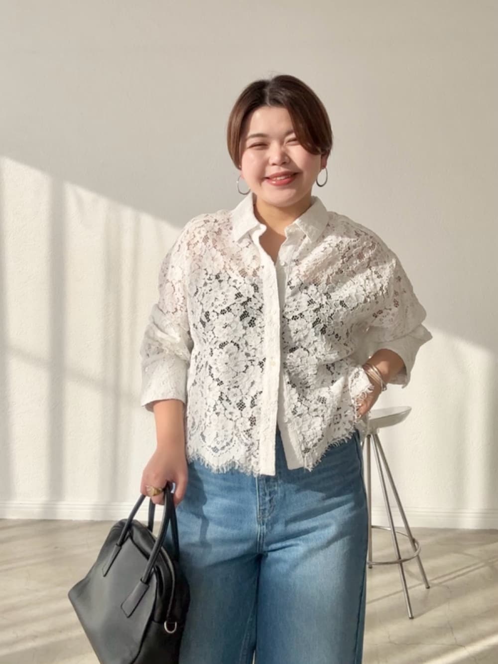 ホワイト系のシャツ/ブラウス、ブルー系のデニムパンツを着用したレディースの春コーディネートの3枚目の写真