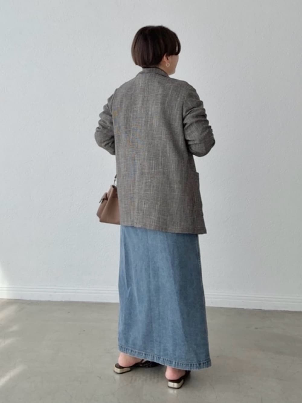 ブルー系のワンピース、ブラック系のテーラードジャケットを着用したレディースの春コーディネートの3枚目の写真