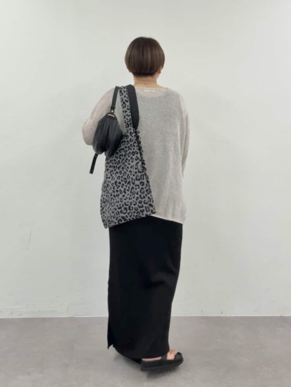 グレー系のニット/セーター、ブラック系のワンピースを着用したレディースの春コーディネートの3枚目の写真