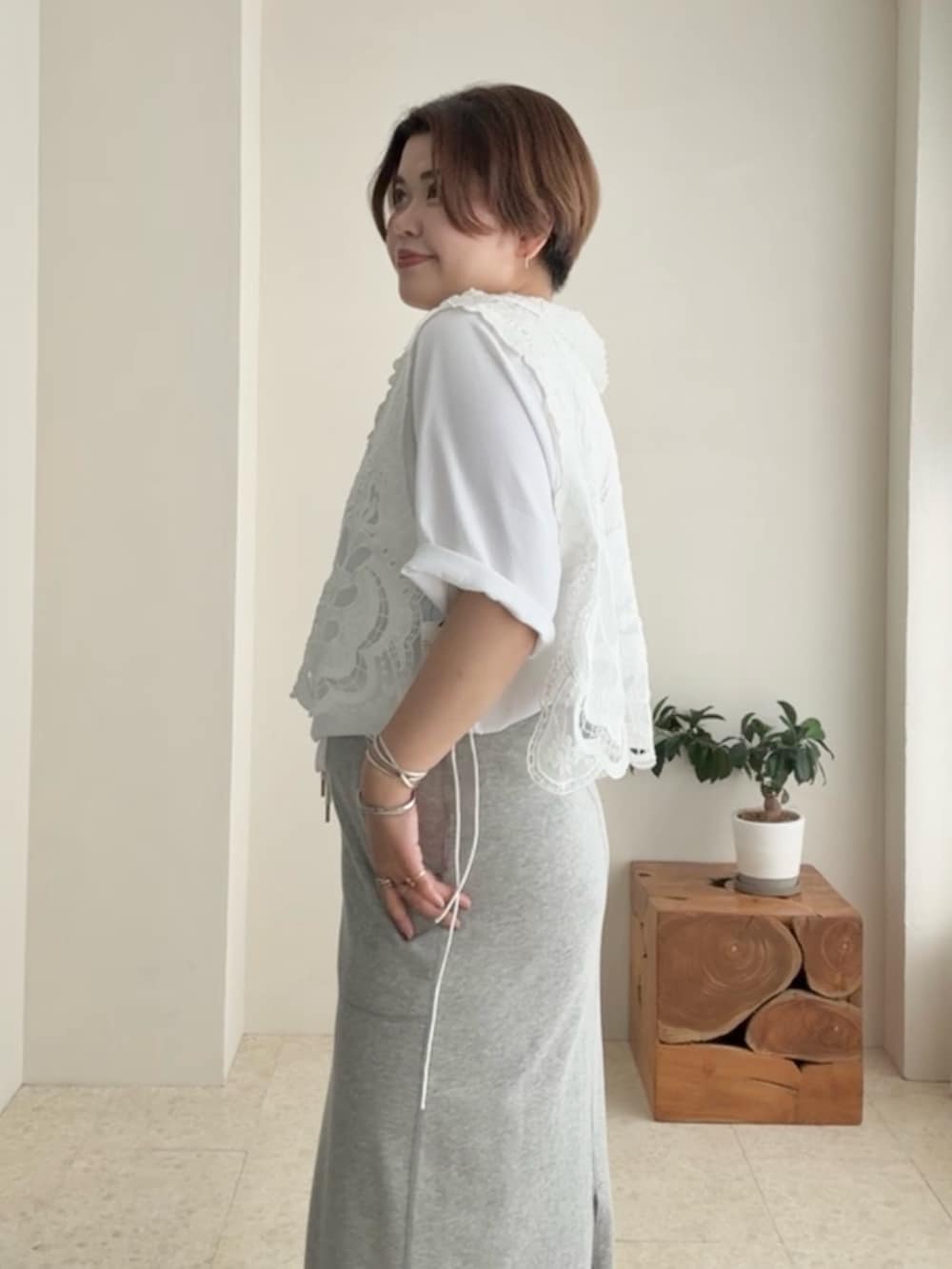 ホワイト系のTシャツ/カットソー、ホワイト系のベスト、グレー系のスカートを着用したレディースの夏コーディネートの4枚目の写真