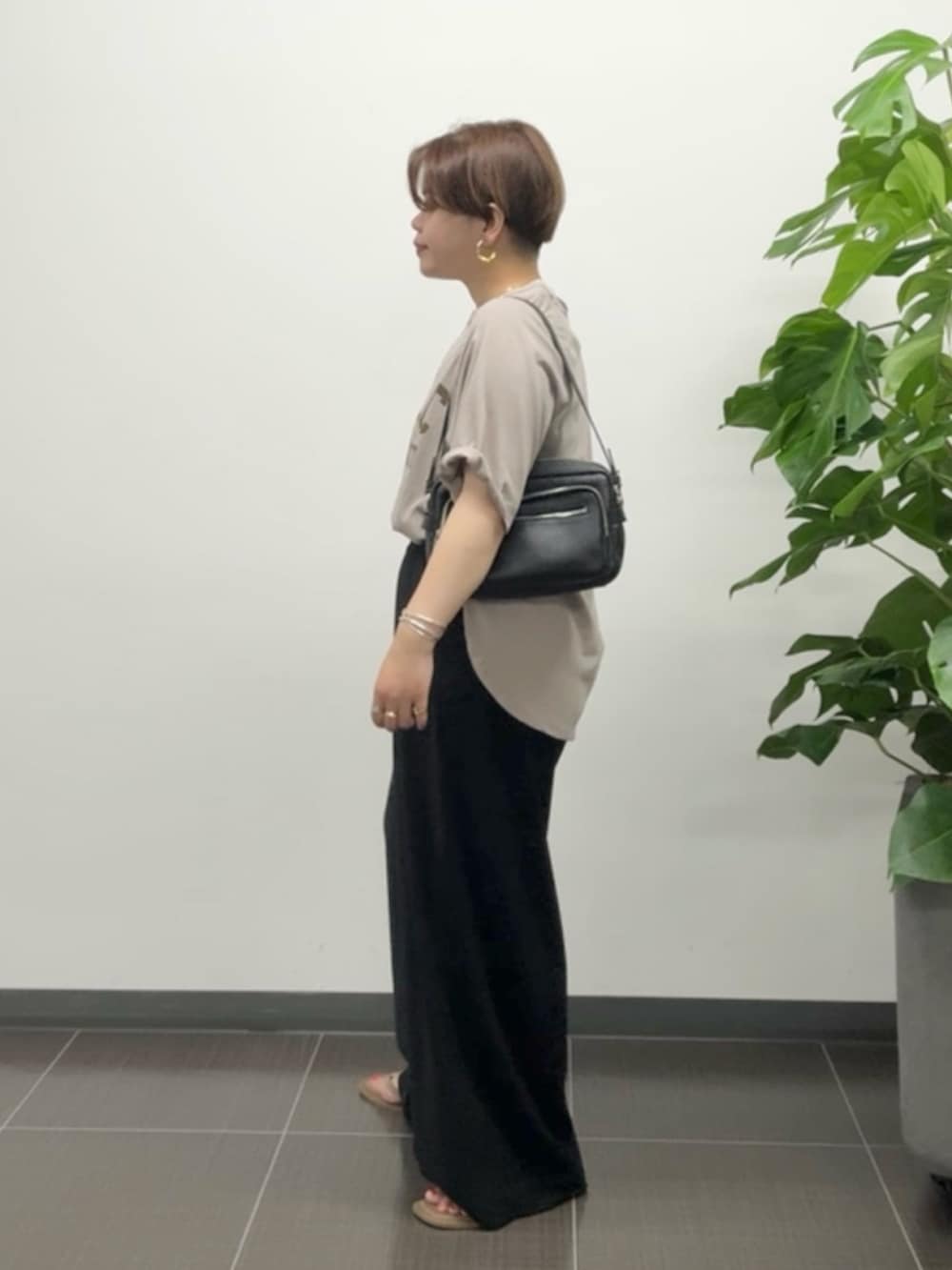 ブラウン系のTシャツ/カットソー、ブラック系のスラックスを着用したレディースの夏コーディネートの2枚目の写真