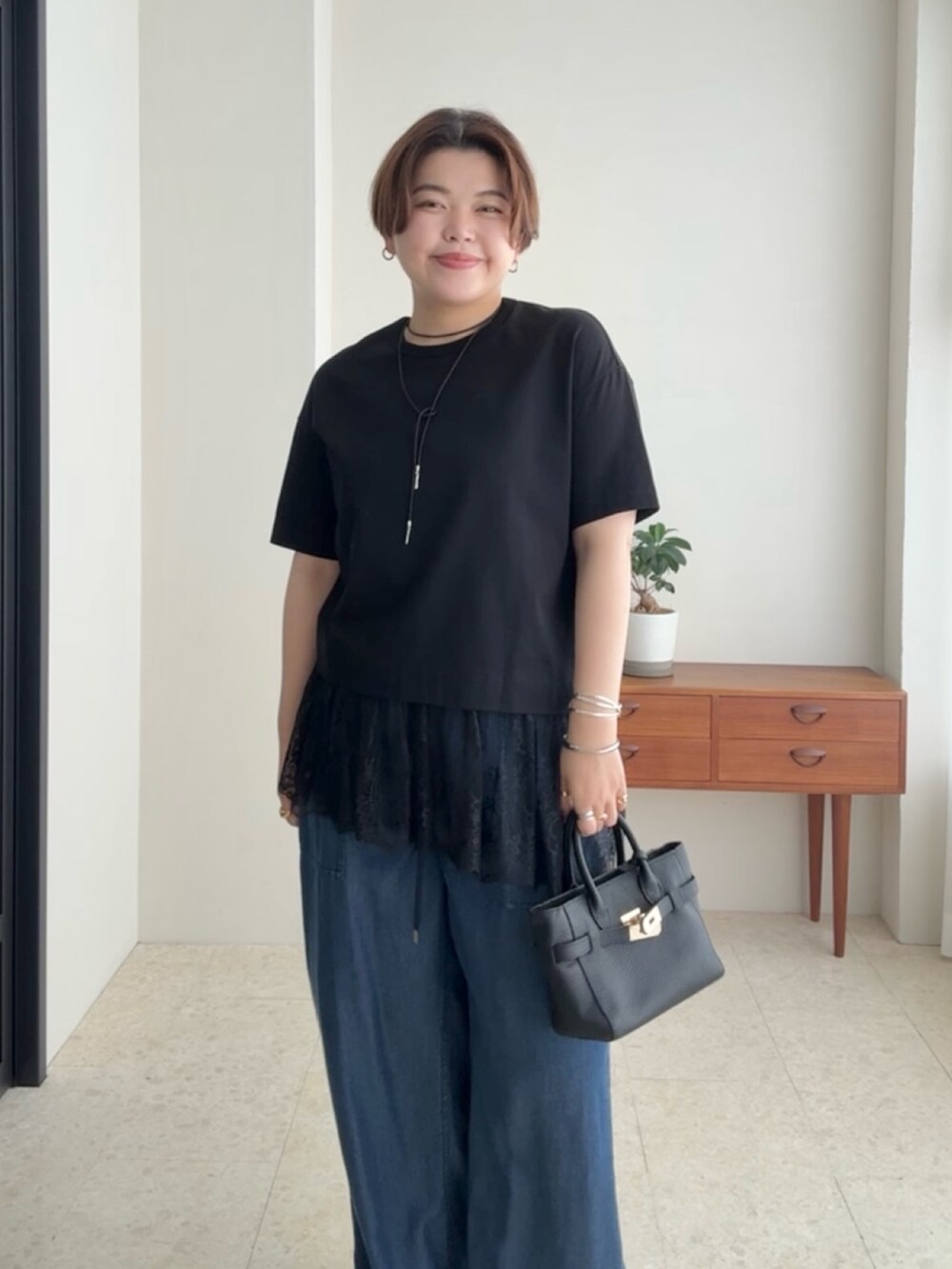 ブラック系のTシャツ/カットソー、ブルー系のデニムパンツを着用したレディースの夏コーディネートの4枚目の写真