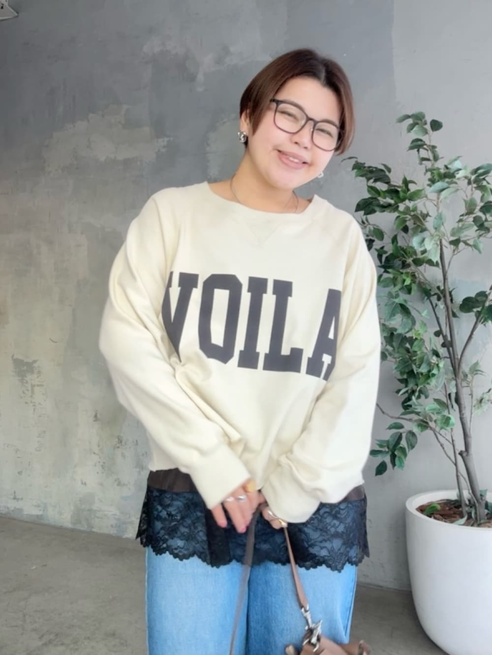 ホワイト系のスウェット、ブラウン系のキャミソール、ブルー系のデニムパンツを着用したレディースの冬コーディネートの5枚目の写真