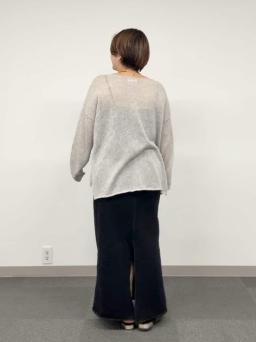 グレー系のニット/セーター、ブラック系のスカートを着用したレディースの春コーディネートの3枚目の写真