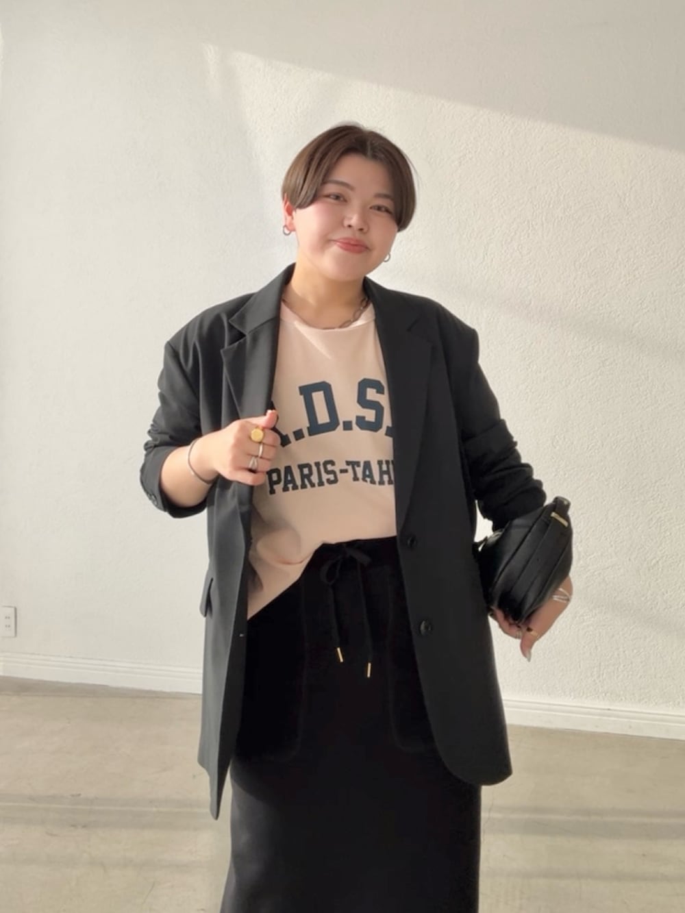 ブラック系のテーラードジャケット、ブラック系のスカート、ピンク系のTシャツ/カットソーを着用したレディースの春コーディネートの4枚目の写真