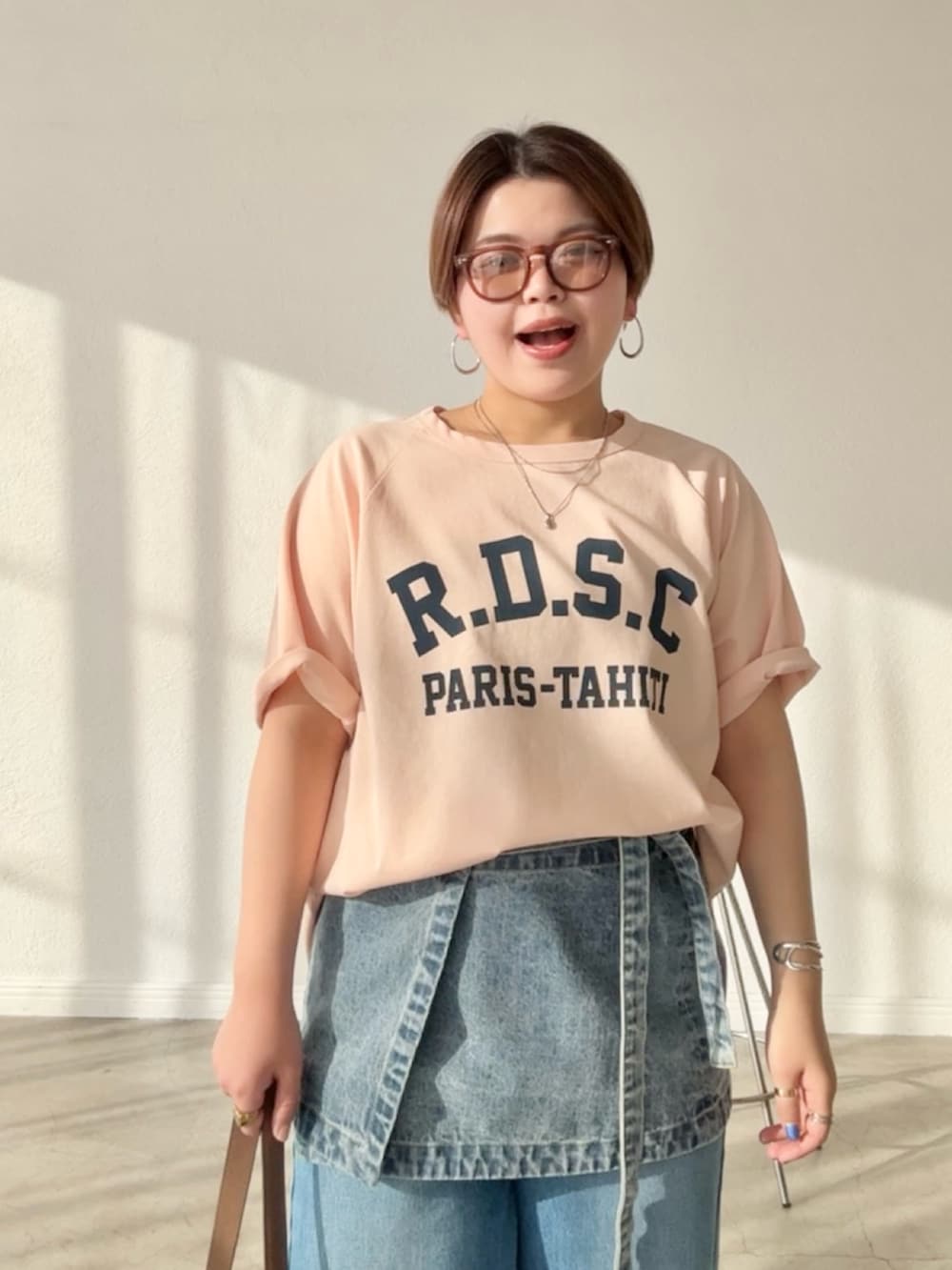 ピンク系のTシャツ/カットソー、ブルー系のデニムスカート、ブルー系のデニムパンツを着用したレディースの春コーディネートの4枚目の写真
