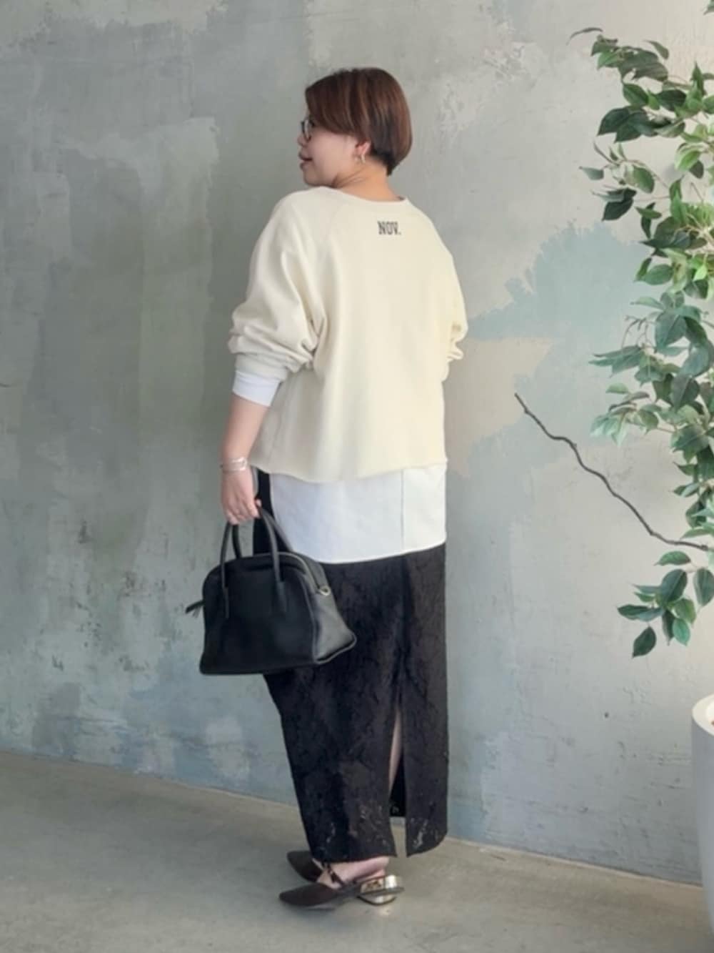 ホワイト系のスウェット、ホワイト系のTシャツ/カットソー、ブラック系のスカートを着用したレディースの冬コーディネートの2枚目の写真