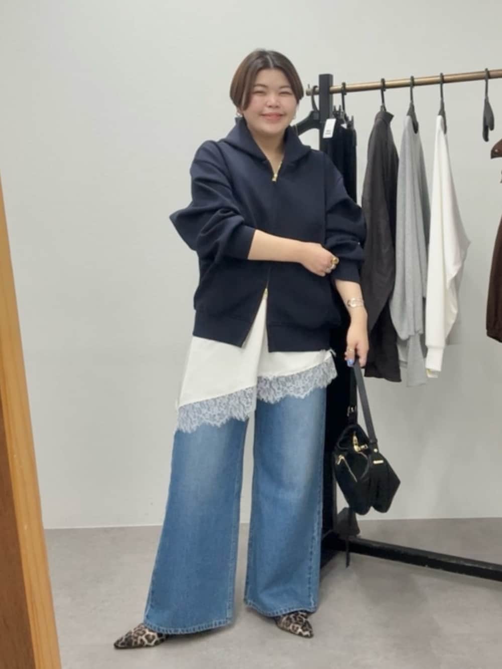 ブルー系のパーカー、ホワイト系のキャミソール、ブルー系のデニムパンツを着用したレディースの春コーディネートの2枚目の写真