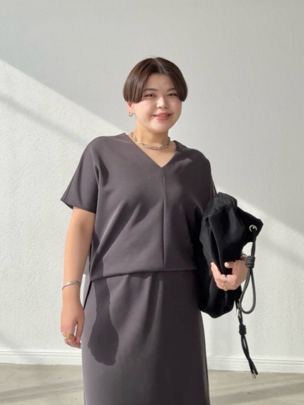 グレー系のTシャツ/カットソー、グレー系のスカートを着用したレディースの春コーディネートの3枚目の写真