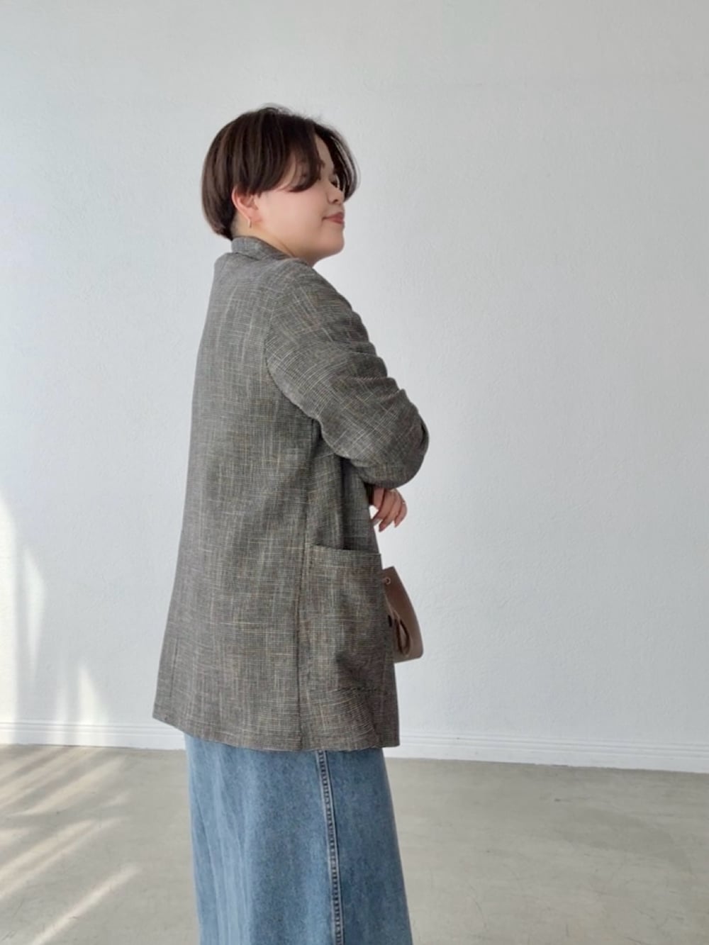 ブルー系のワンピース、ブラック系のテーラードジャケットを着用したレディースの春コーディネートの5枚目の写真