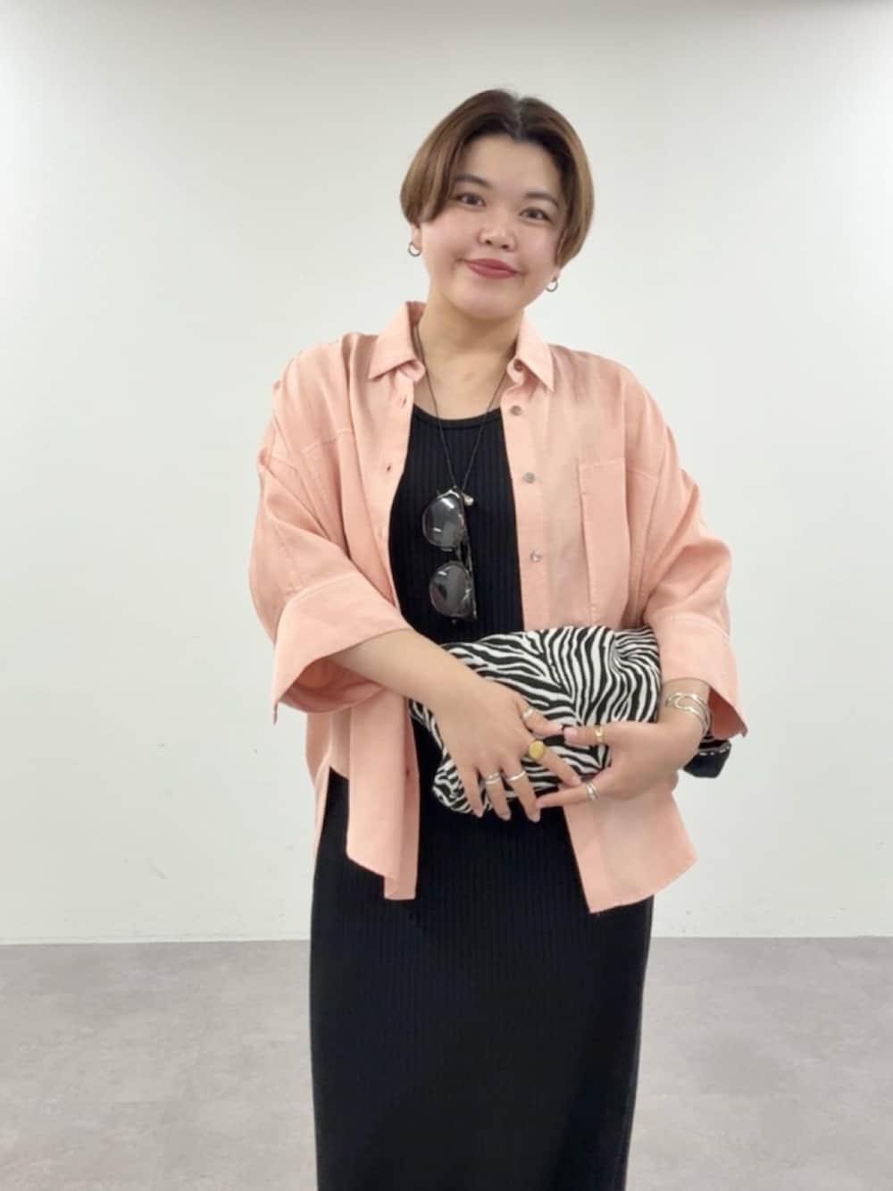 ピンク系のシャツ/ブラウス、ブラック系のワンピース、ブラック系のトートバッグを着用したレディースの夏コーディネートの3枚目の写真