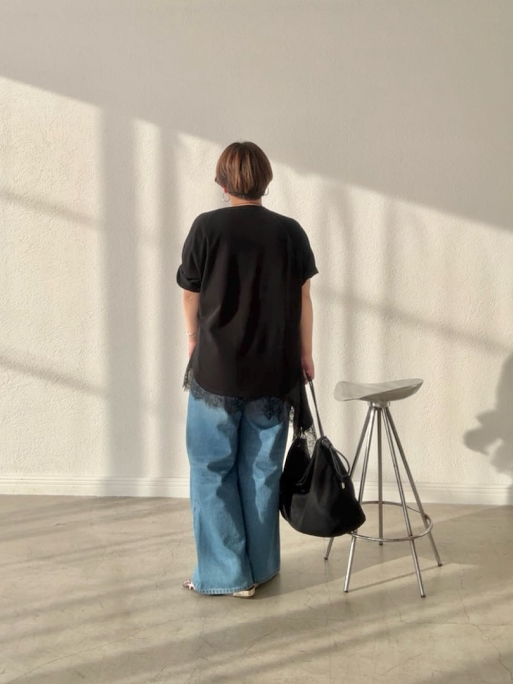 ブラック系のTシャツ/カットソー、ブラック系のキャミソール、ブルー系のデニムパンツを着用したレディースの春コーディネートの2枚目の写真