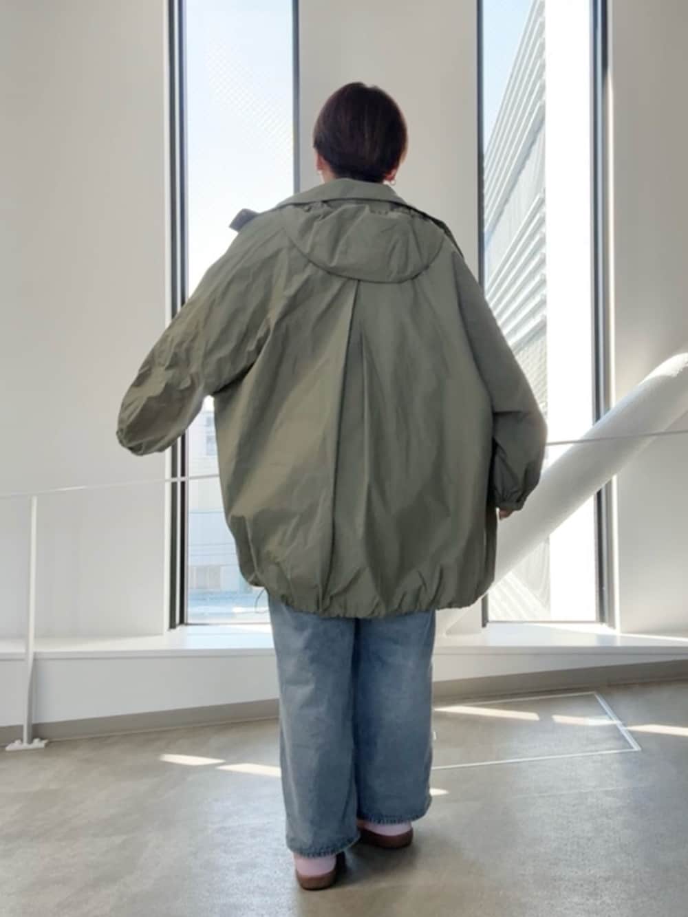 グリーン系のその他アウター、ブルー系のシャツ/ブラウス、ブルー系のデニムパンツを着用したレディースの春コーディネートの3枚目の写真